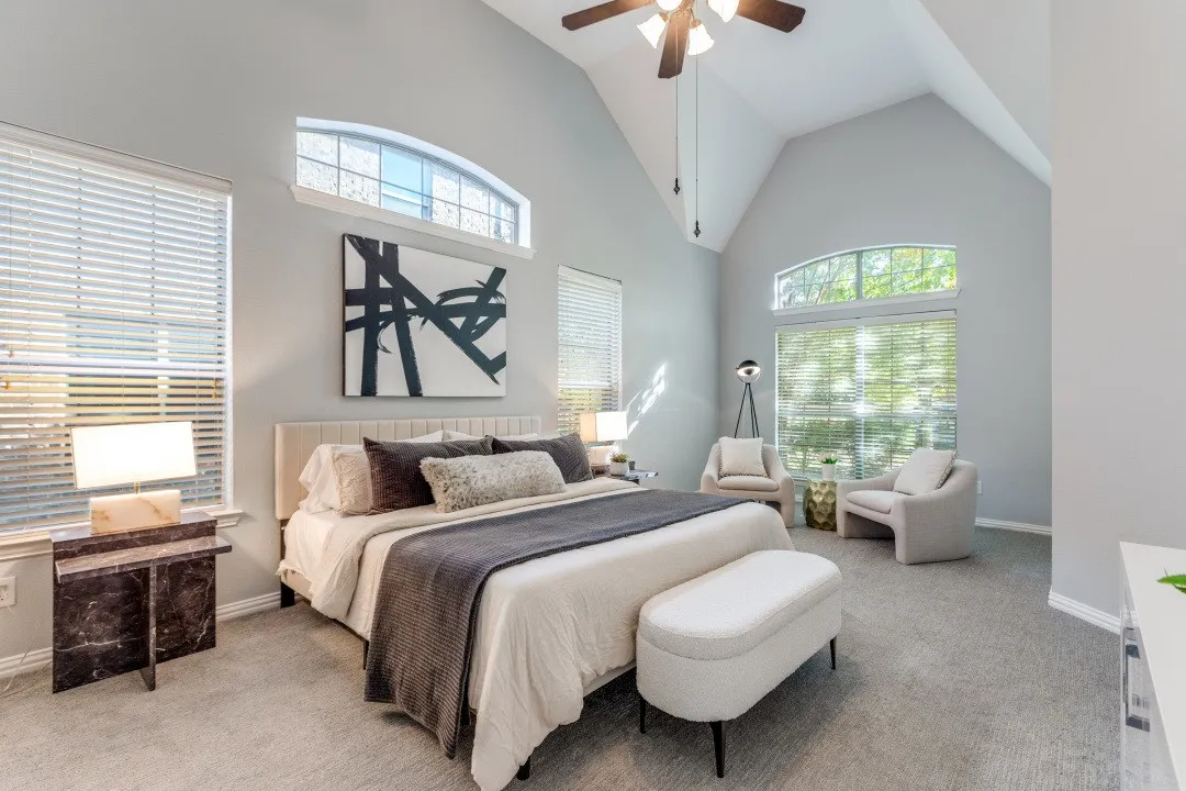 Vaulted ceiling with an attached ceiling fan, arched transom windows, large windows with blinds, and light gray wall paint