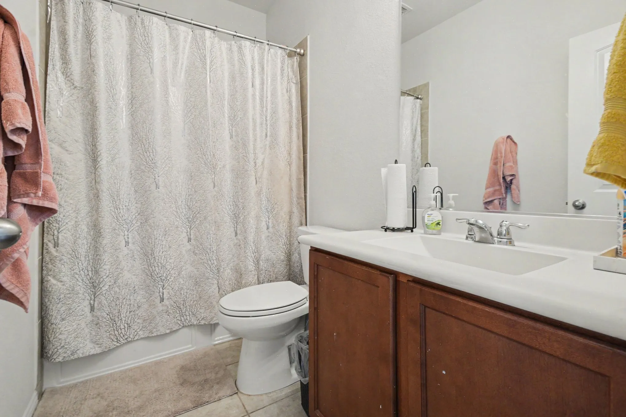 Bathroom featuring a vanity with dark wood-finish cabinetry, an integrated sink, and a chrome faucet
