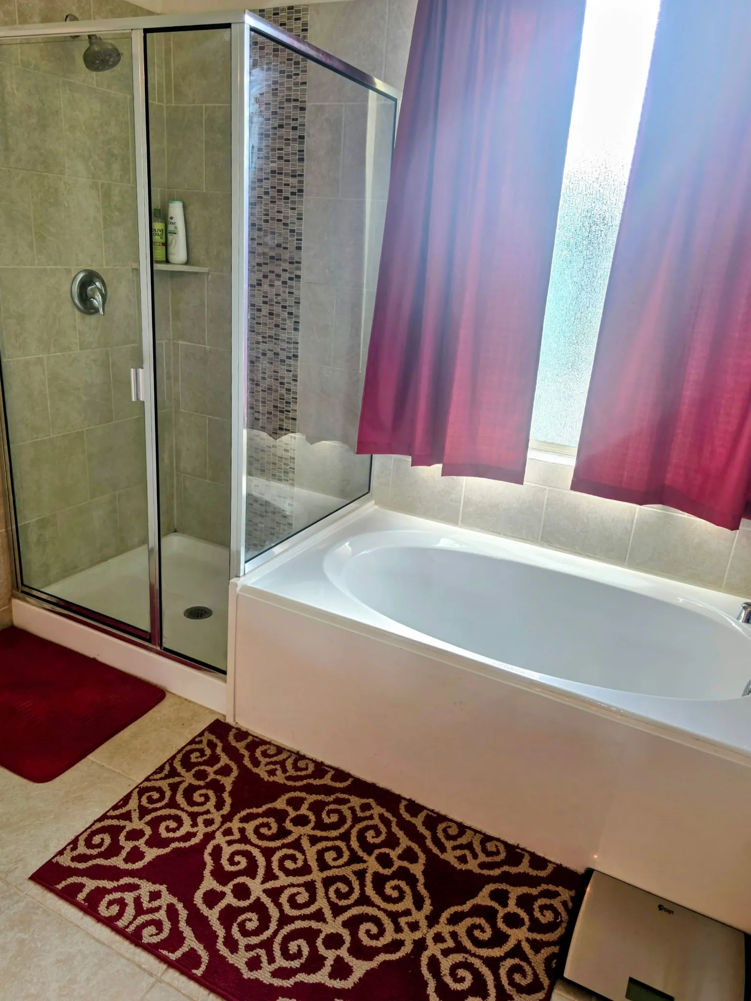 Modern bathroom featuring a walk-in shower with clear glass enclosure, a built-in shower shelf, and a tiled accent wall