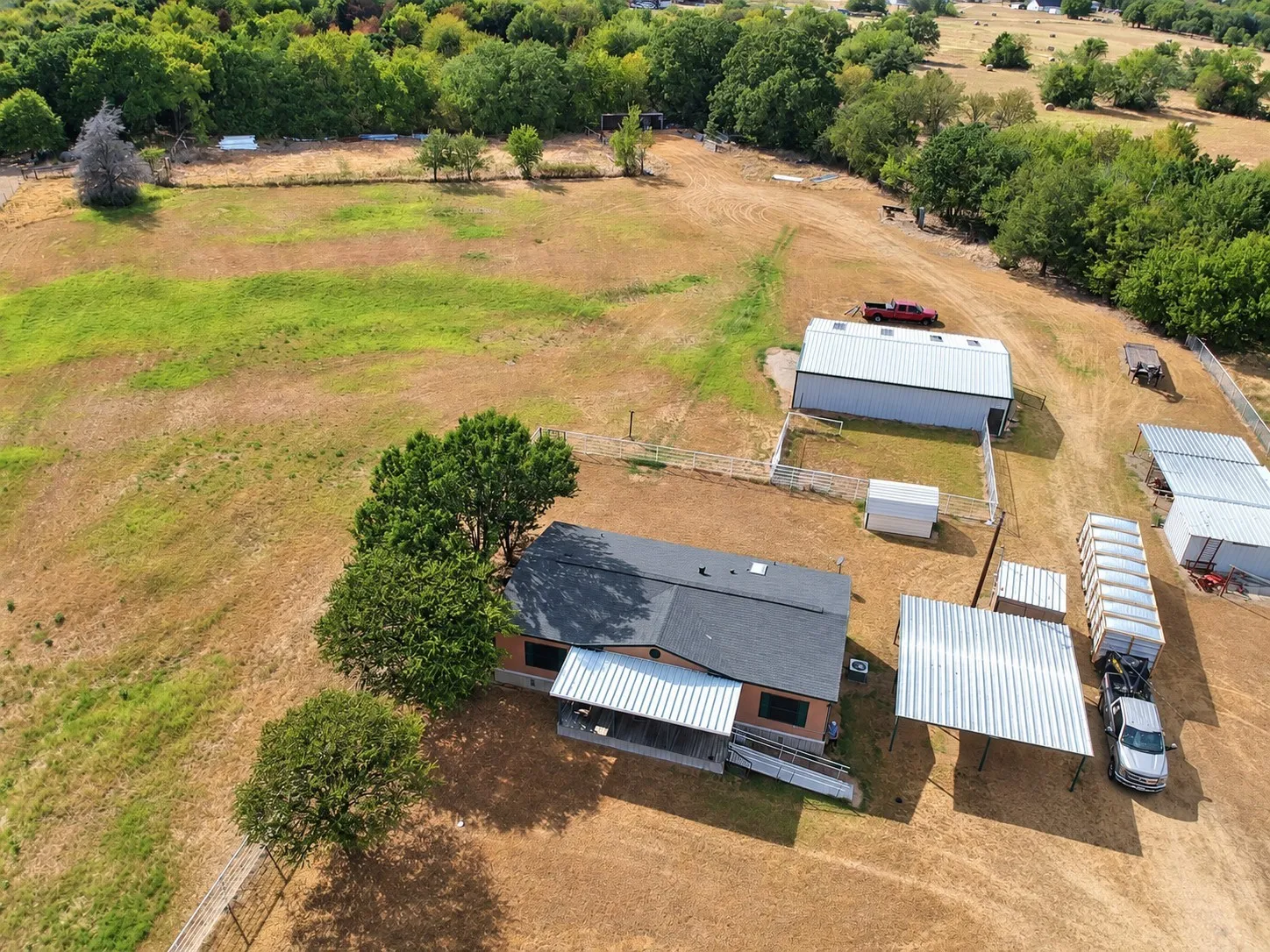 Expansive property featuring a main residence, large outbuilding, and additional covered structures
