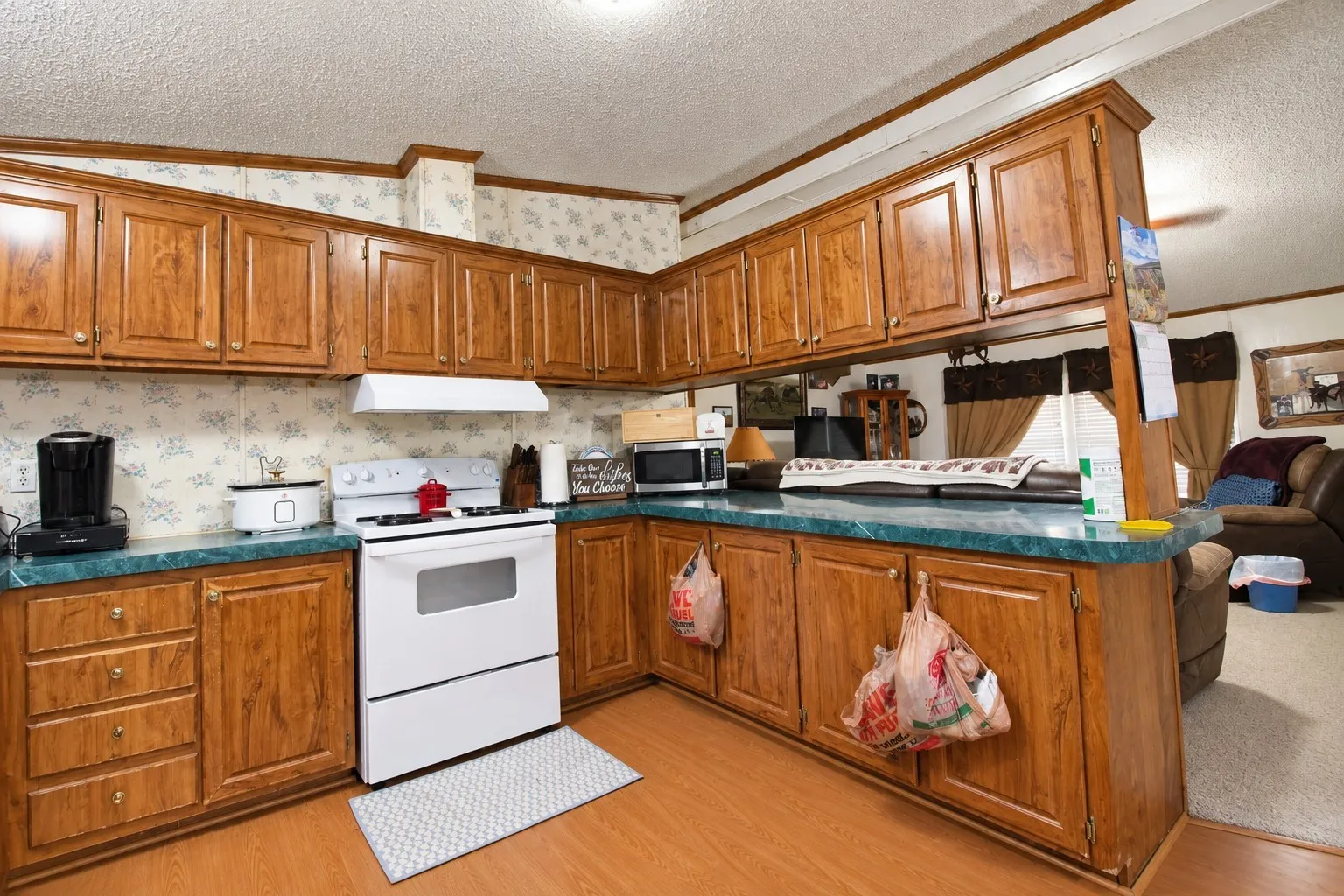 Kitchen featuring wood-finish cabinetry, a white range, and a turquoise-finish countertop