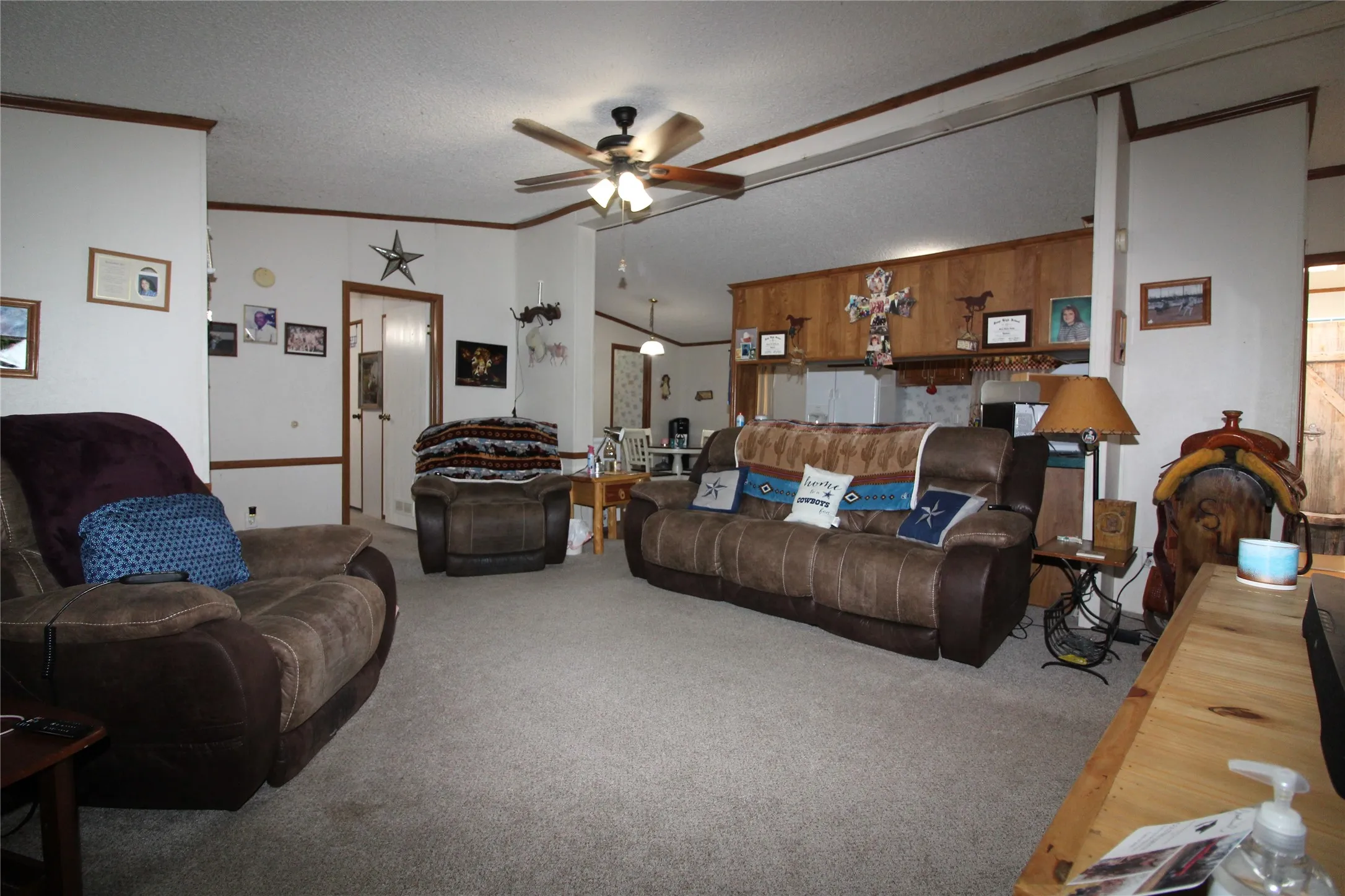 Carpeted flooring, ceiling fan with light fixture, wood-paneled accents, and white wall finishes
