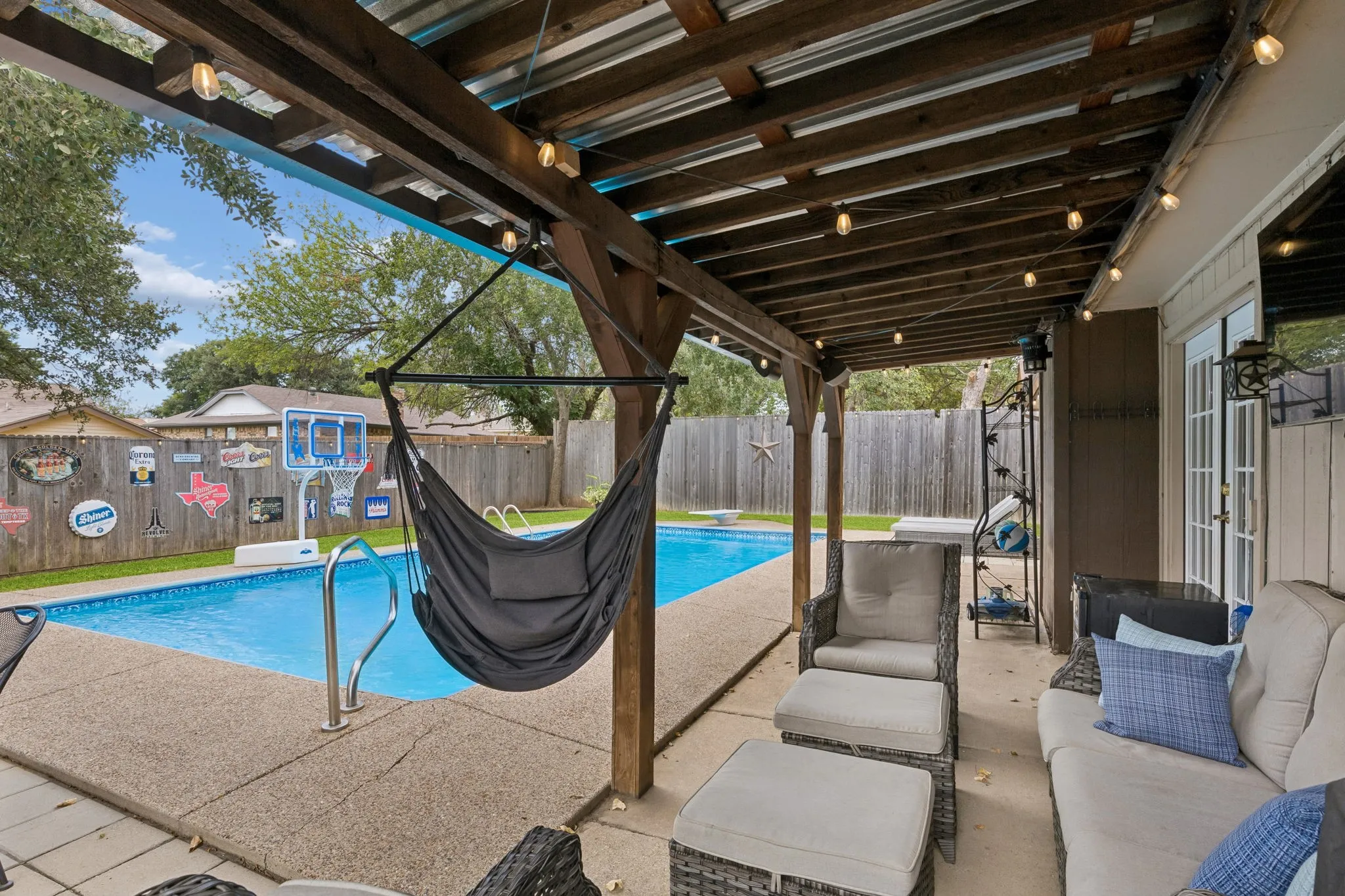 Covered patio with accent lighting (conveys) and view of sparking pool
