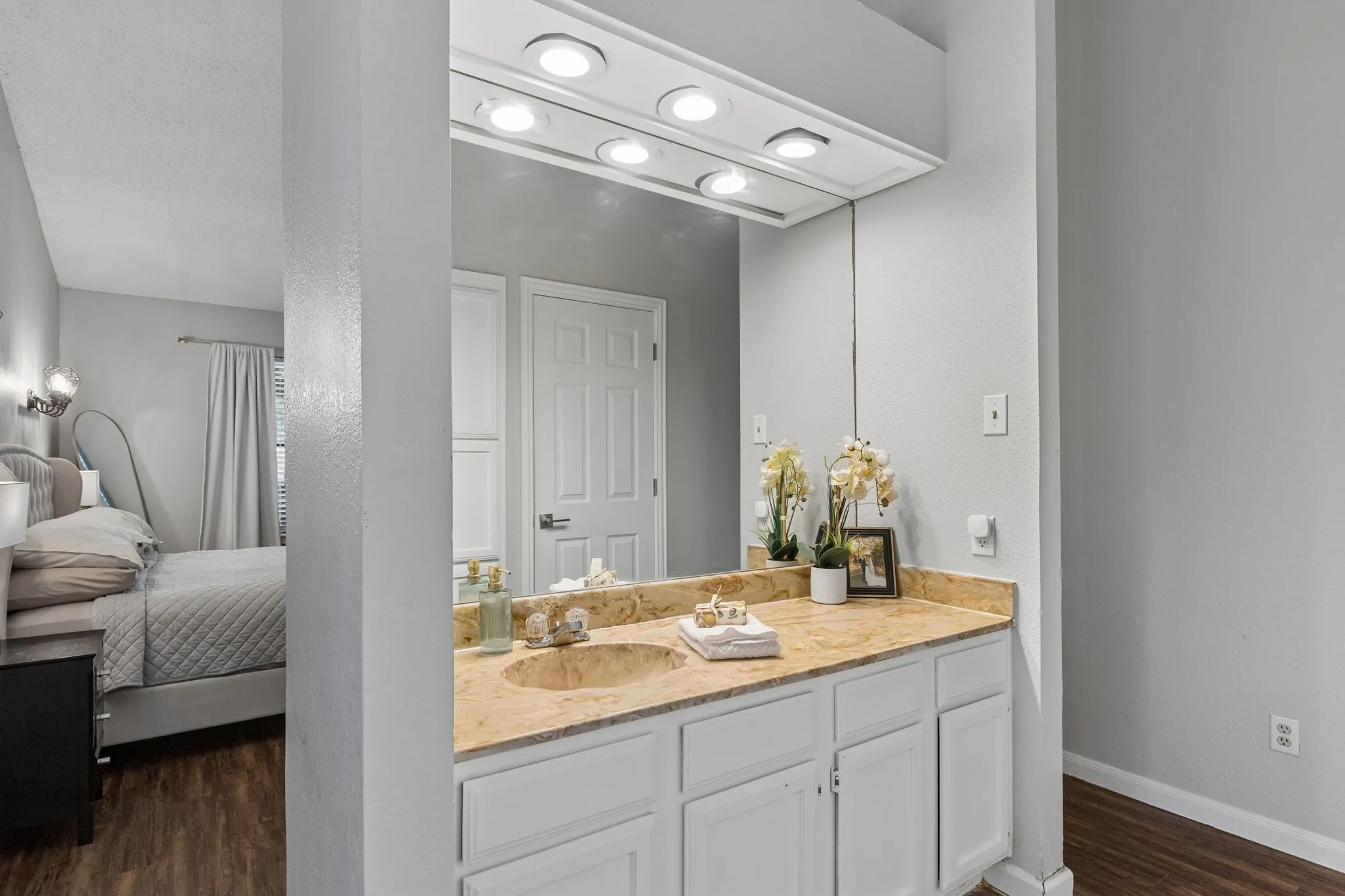 Primary bathroom vanity with view of primary bedroom