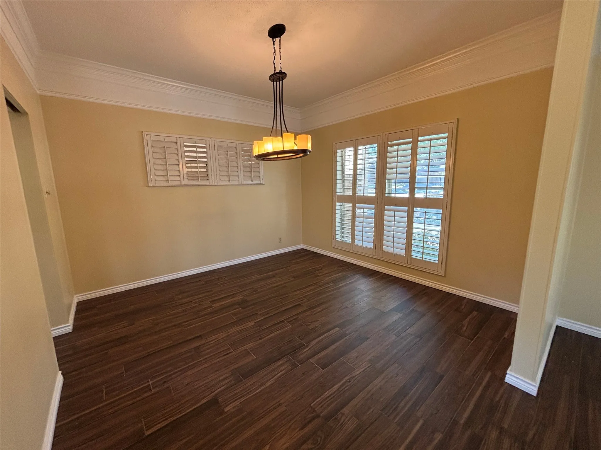 Wood-finish flooring, crown molding, and plantation shutters