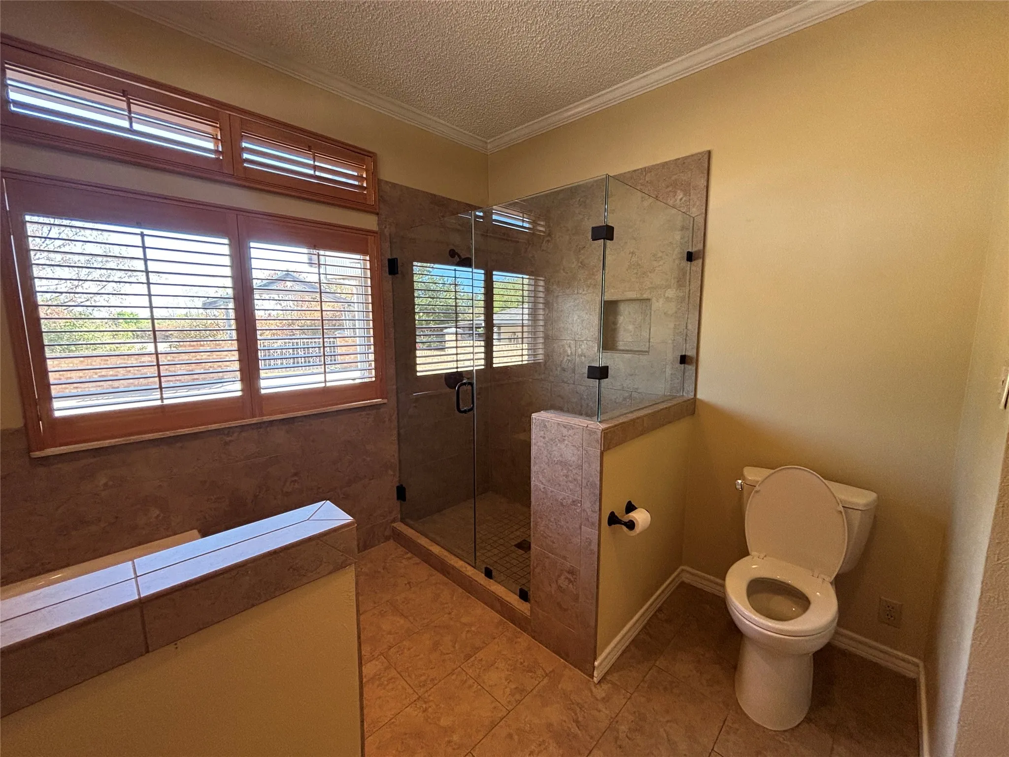 Glass-enclosed shower with a tiled interior, featuring a built-in niche