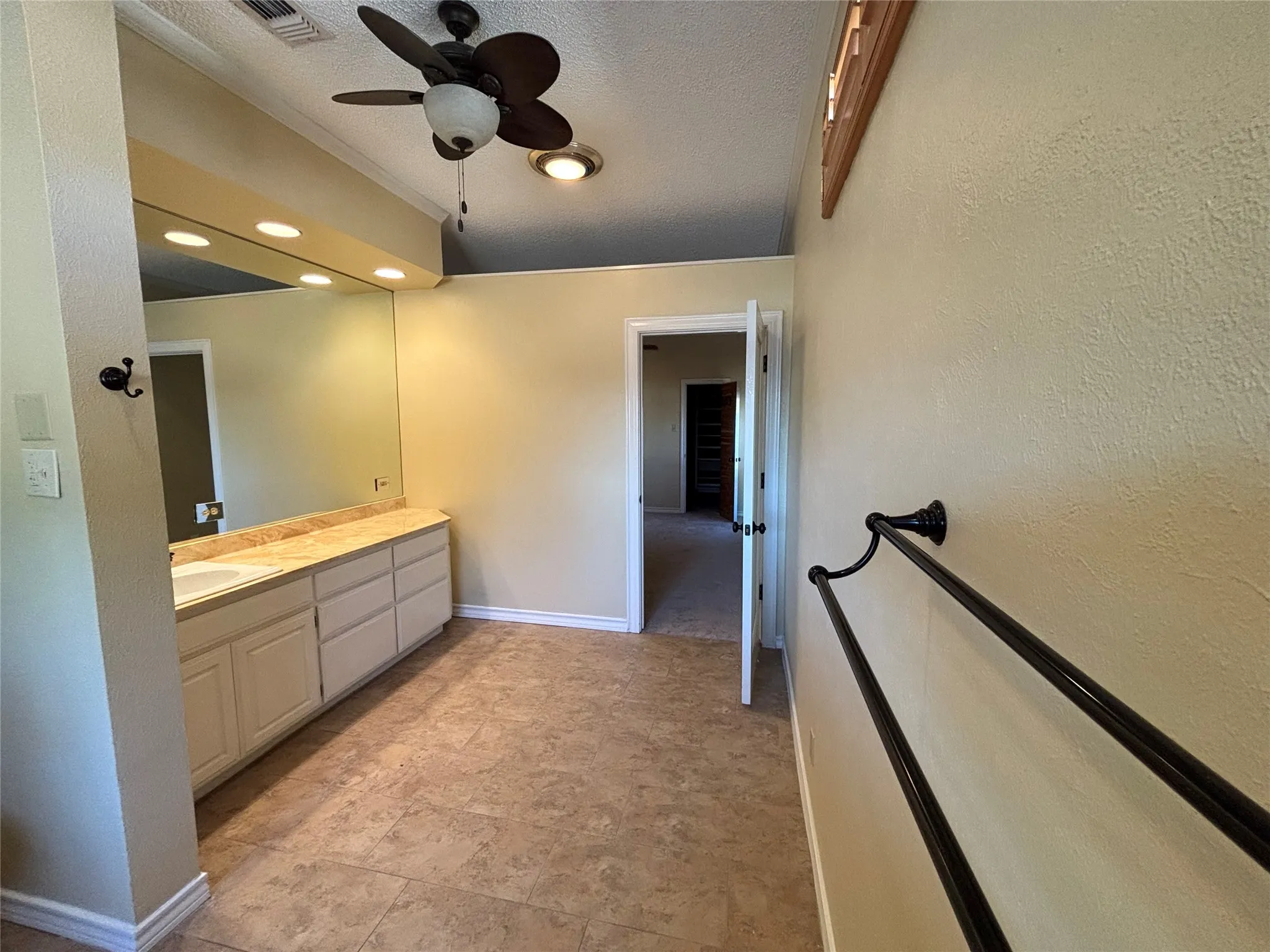 Long vanity with integrated sink, full-width mirror, and overhead lighting