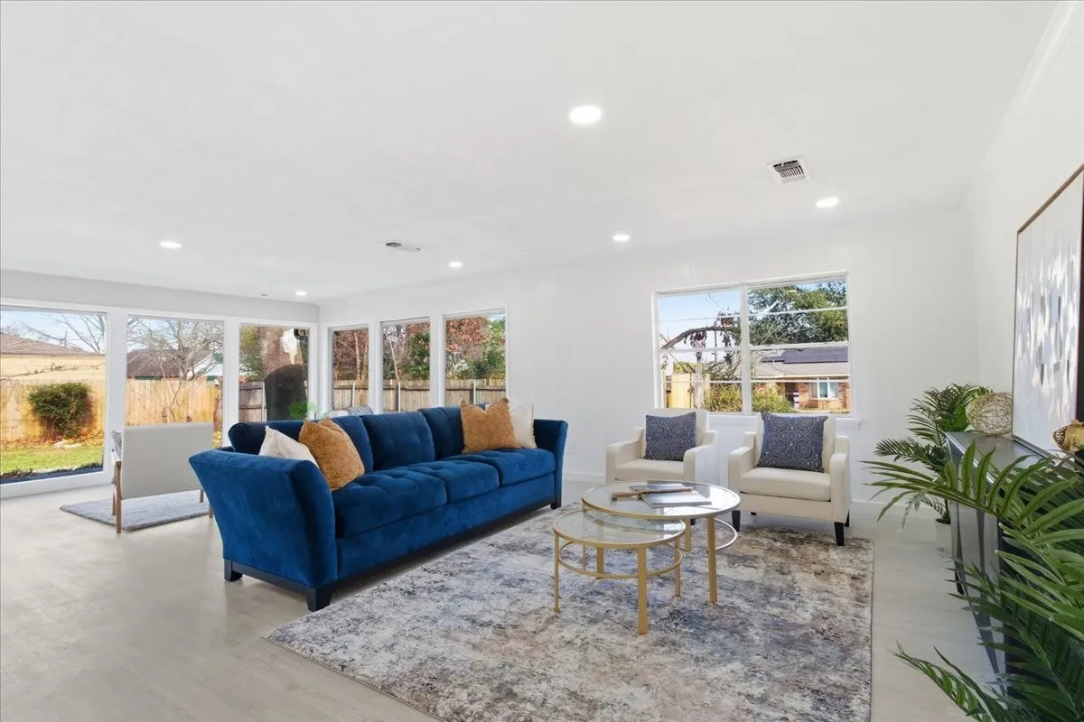 Recessed lighting, light wood-finish flooring, white walls, and multiple large windows