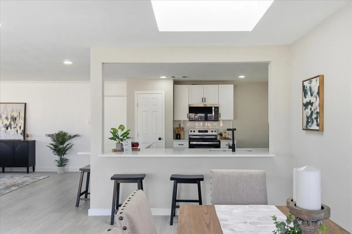 Kitchen with white cabinetry, stainless steel appliances, and a pass-through counter