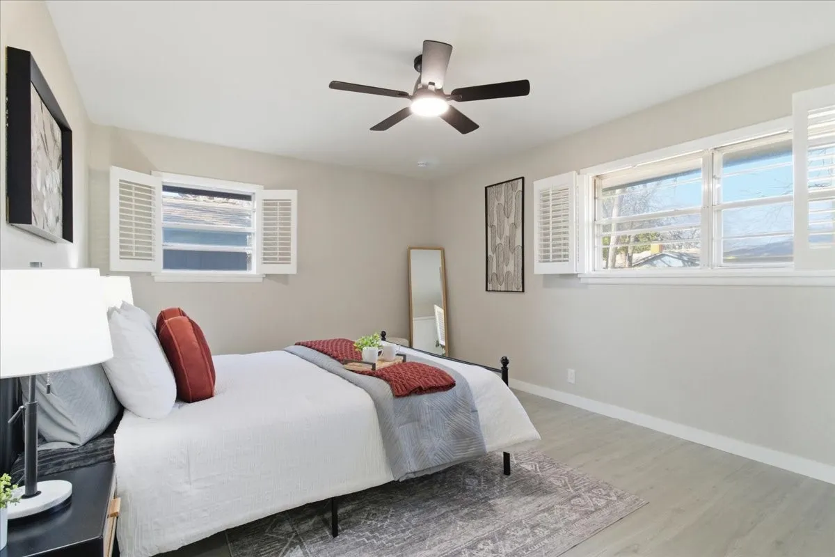 Recessed lighting and ceiling fan, multiple windows with white plantation shutters, and light wood-finish flooring