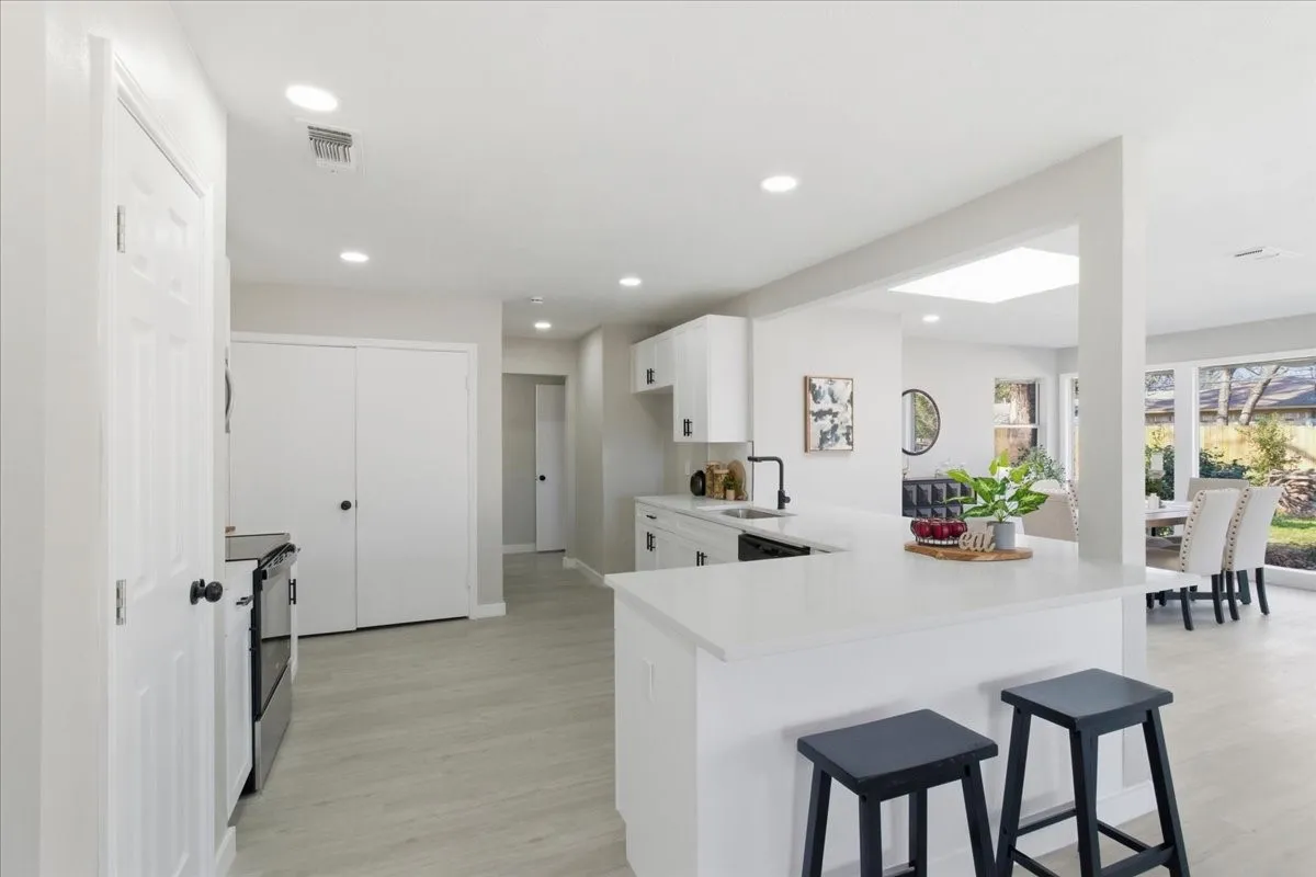Kitchen featuring a white countertop island, recessed lighting, white cabinetry, and wood-finish flooring