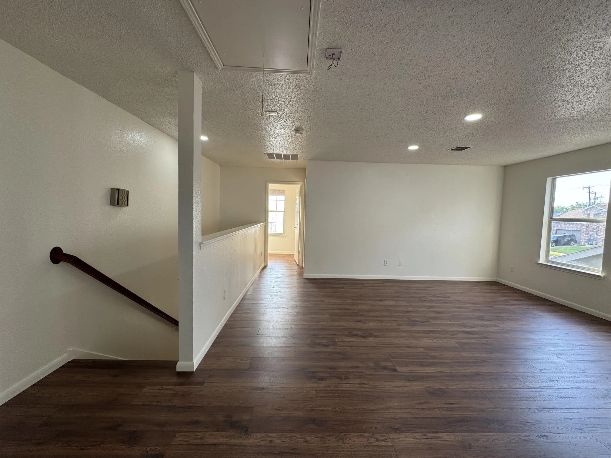 Open-concept room featuring wood-finish flooring, recessed lighting, and white baseboards