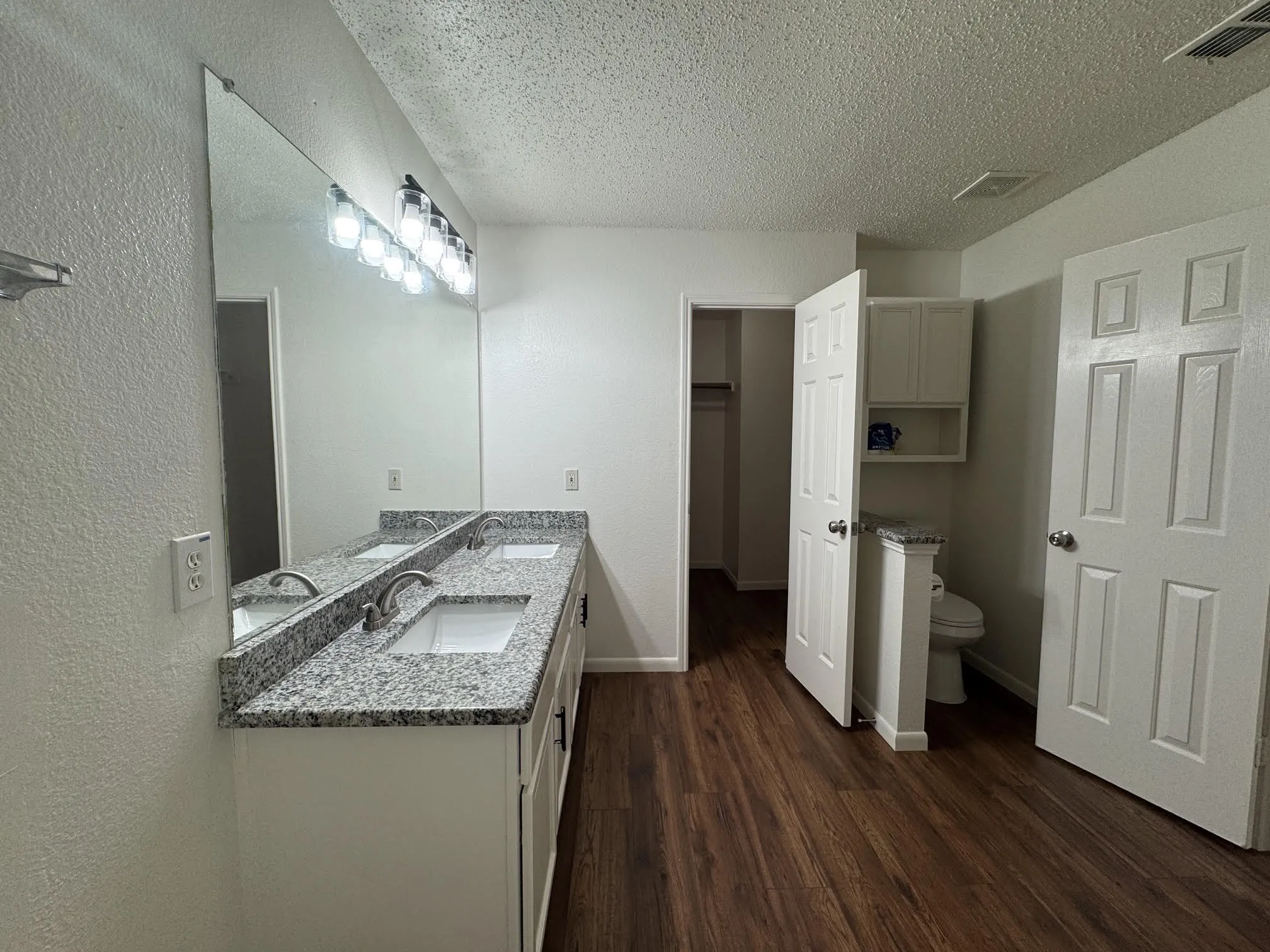 Double vanity with a granite-style countertop, undermount sinks, and brushed nickel faucets
