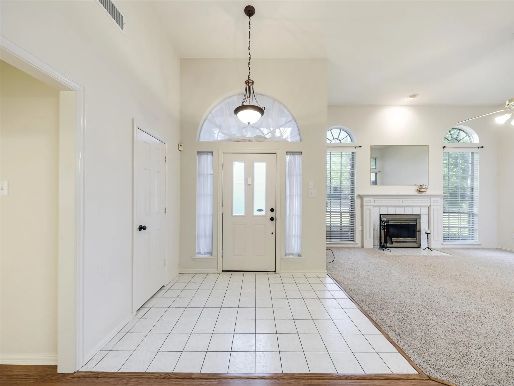 Entry with white tile flooring and vaulted ceilings