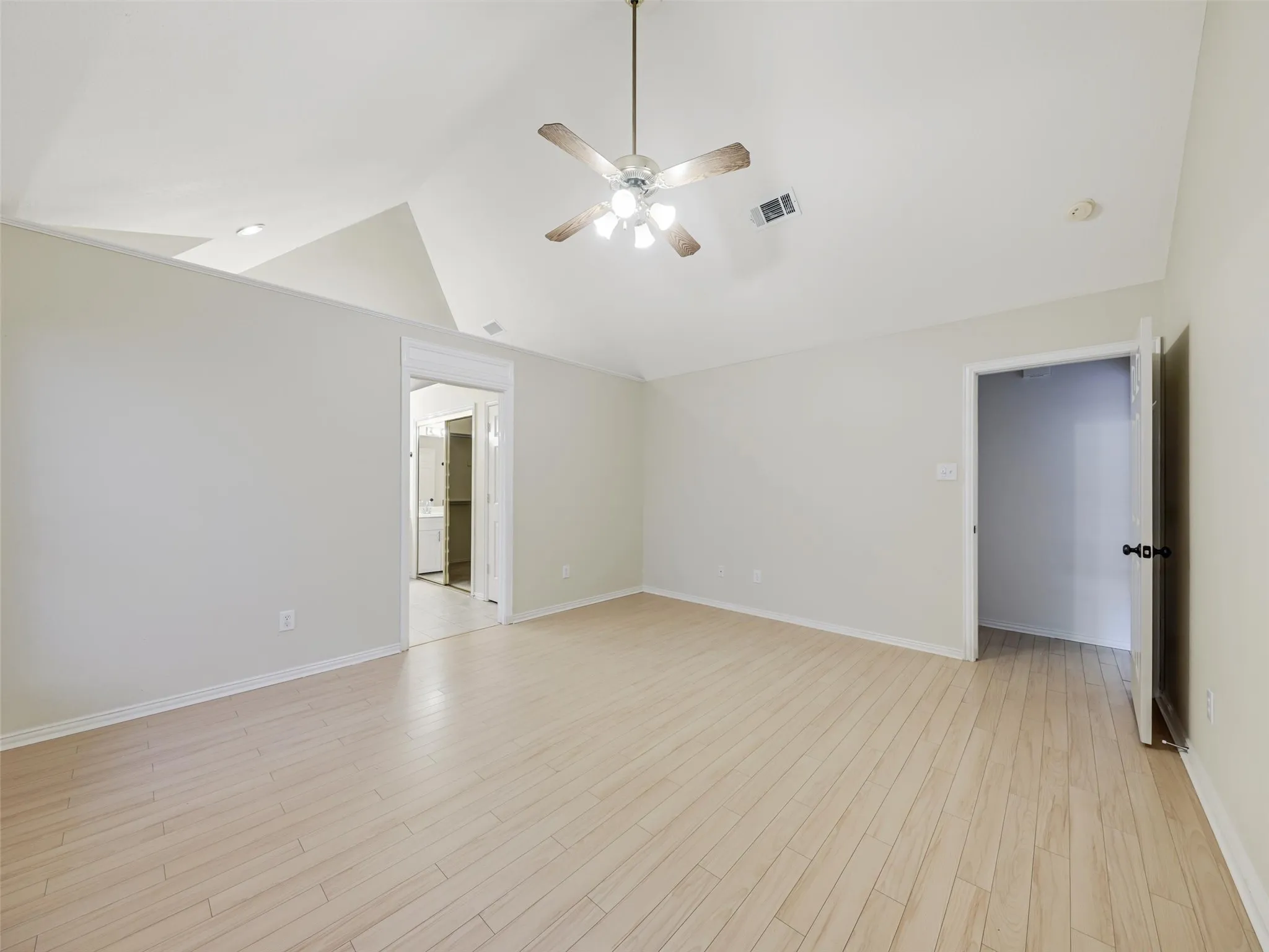 Vaulted ceiling with a ceiling fan, light wood-finish flooring, and recessed lighting