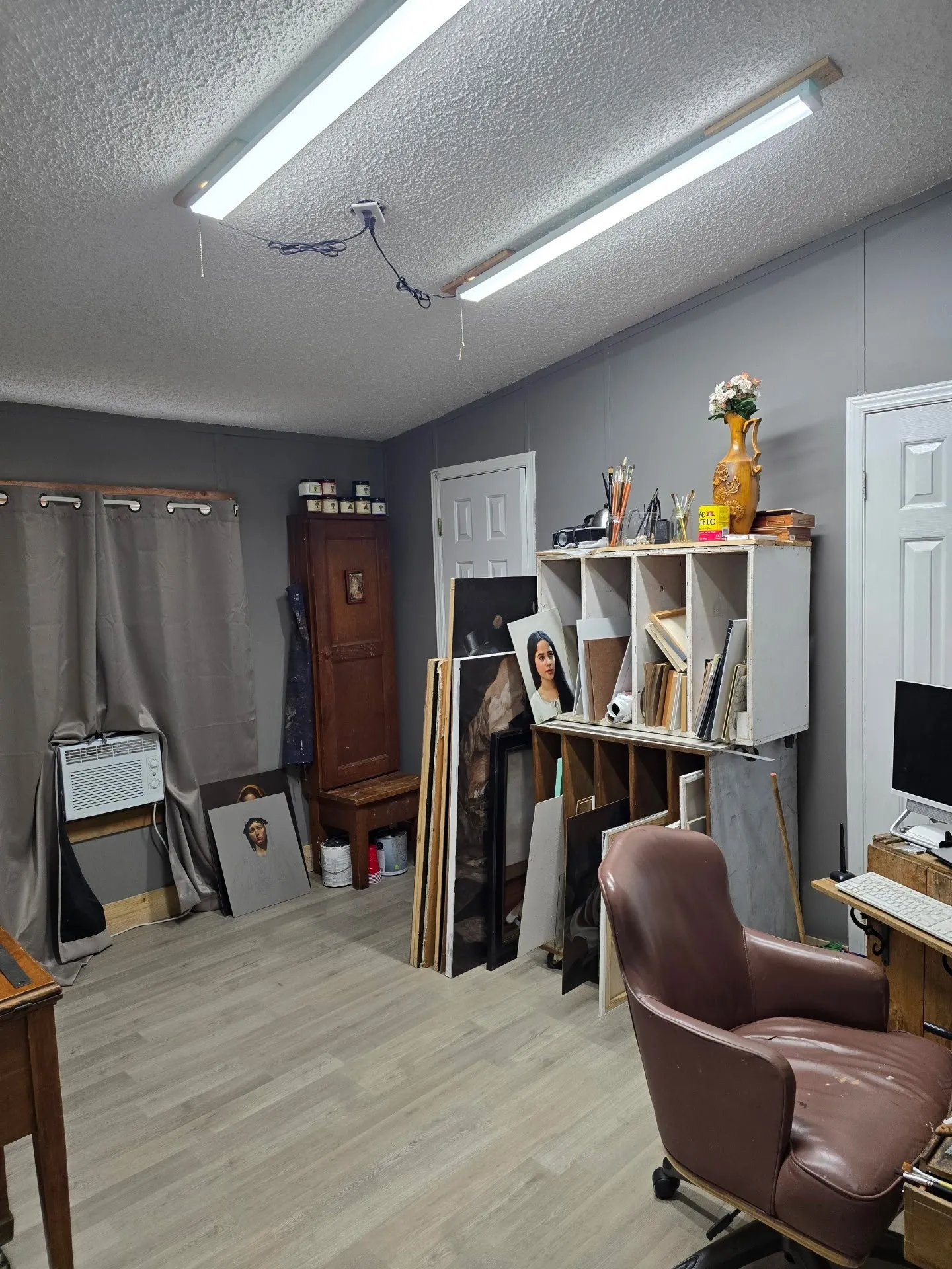 Recessed fluorescent lighting, wood-finish flooring, two panel doors, and a wall-mounted air conditioning unit