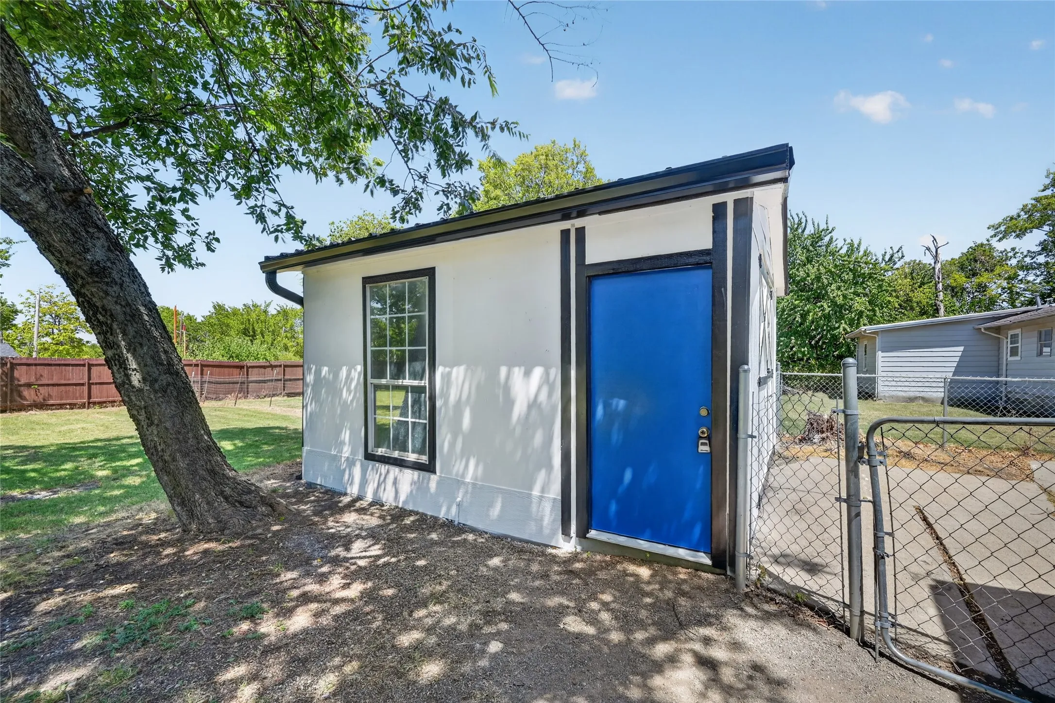 White exterior structure with a bright blue door