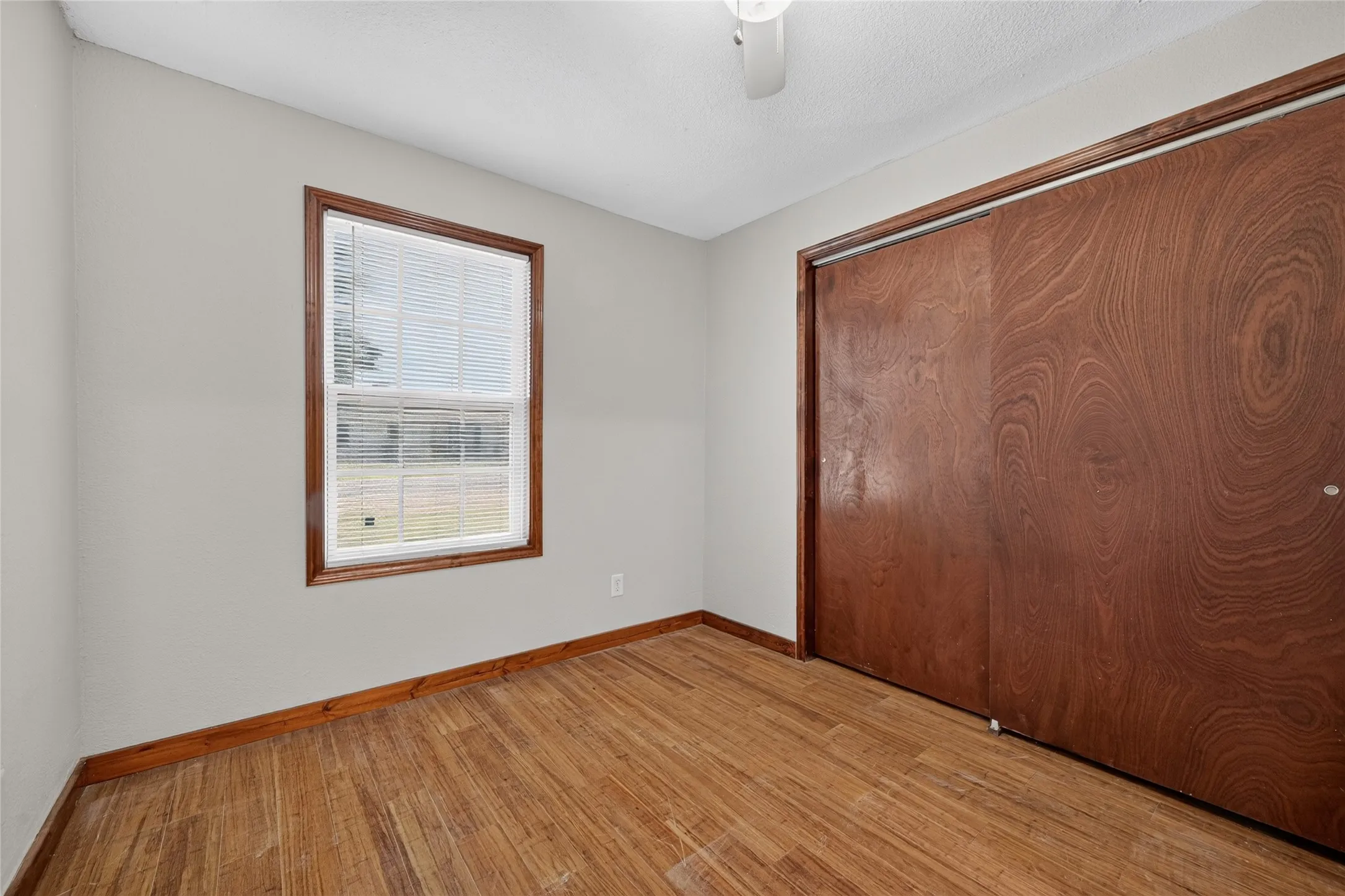 Wood-finish flooring, wood-framed window, wood base trim, and wood-finish closet doors