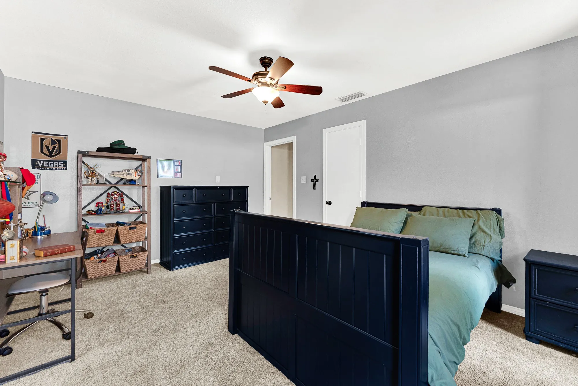 Looking back across the space highlights its comfortable proportions and functional layout. Double-pane windows keep the room bright while leaving plenty of open floor space for a full furniture suite and dedicated study desk.