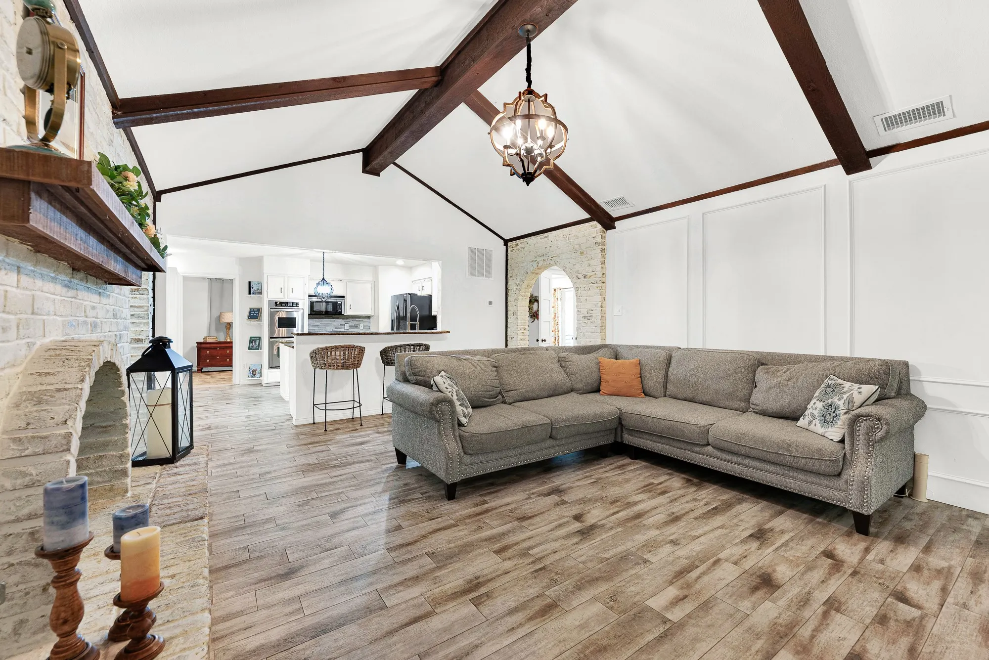 Looking across the wood-look tiled floors, this perspective highlights the open flow directly into the kitchen and breakfast bar. You will love how simple it is to chat with guests in the kitchen without ever missing a moment of the conversation