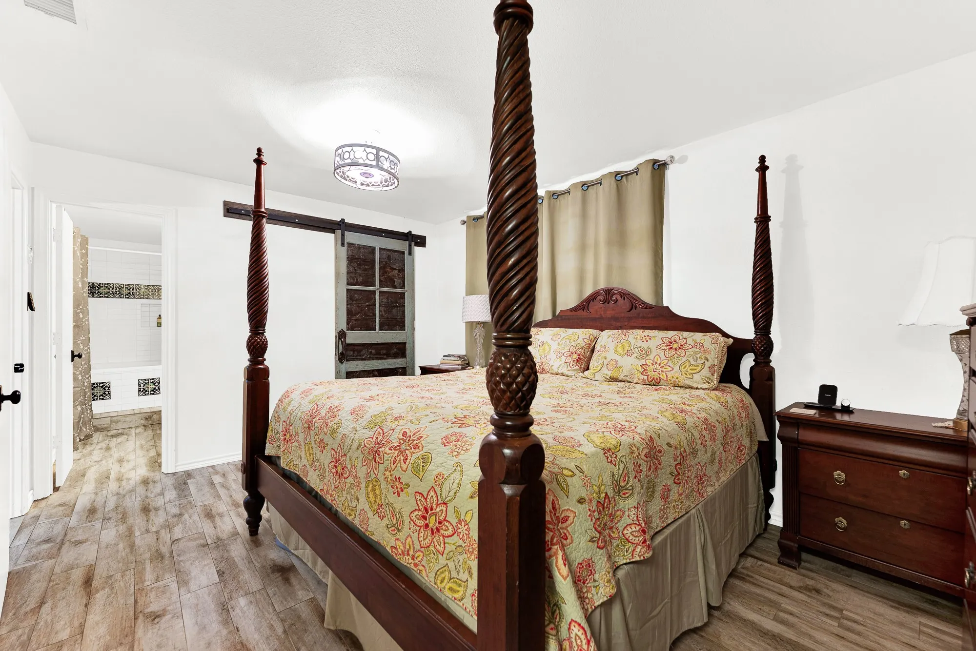 Positioned for total convenience, the main bedroom offers immediate access to a private en-suite bath. Modern overhead lighting and warm natural tones complete a cozy environment built for ultimate comfort