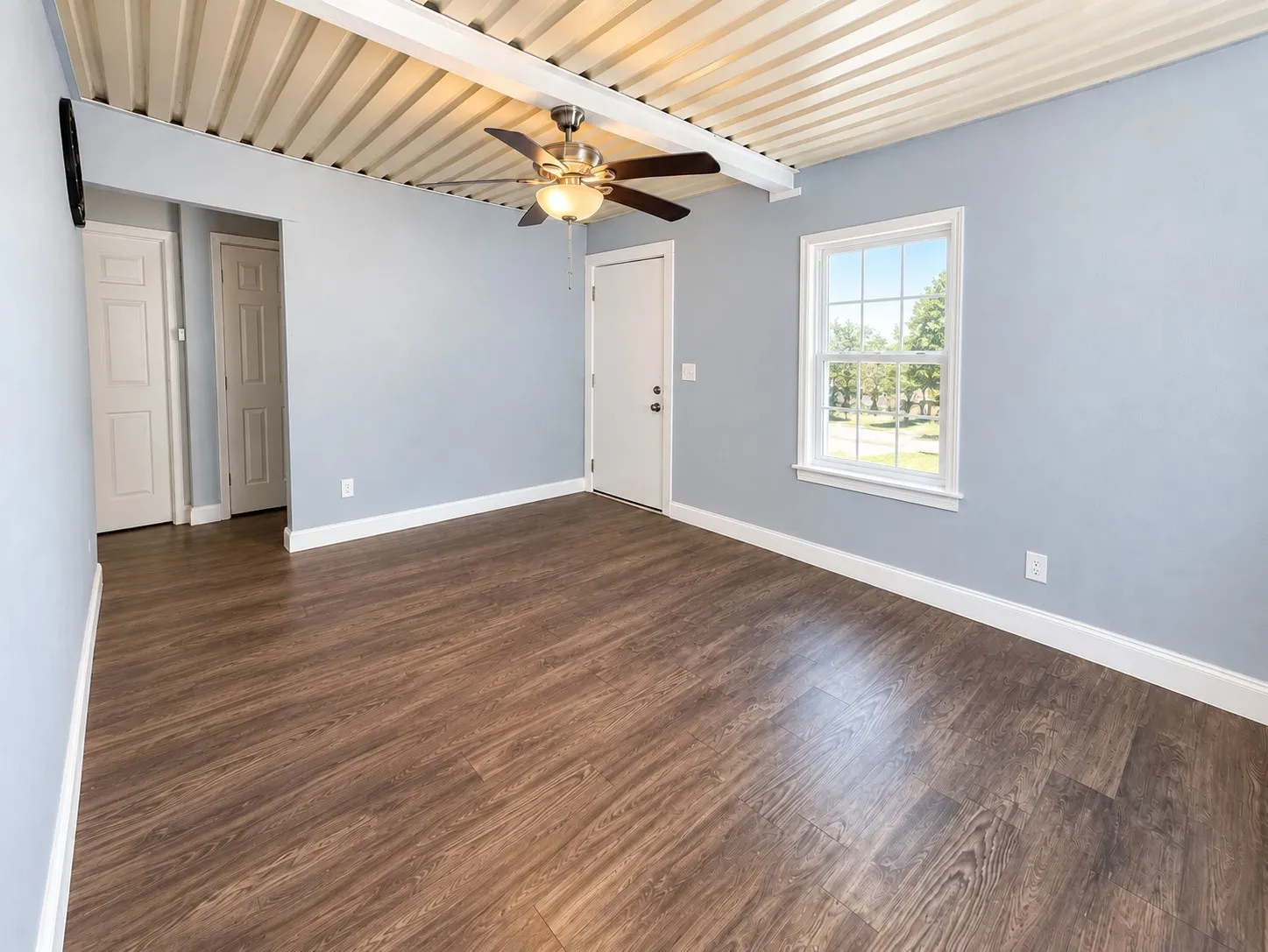 Second home living area with a ceiling fan and wood-look flooring.