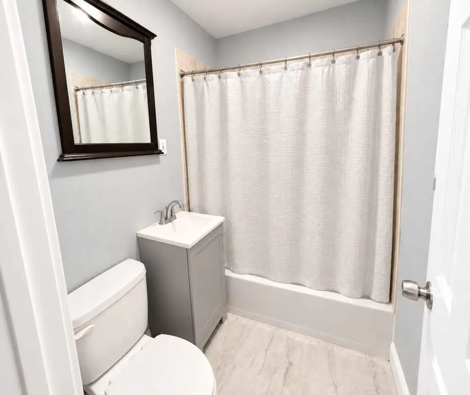 Second home bathroom with a pedestal sink and tub and shower combination.