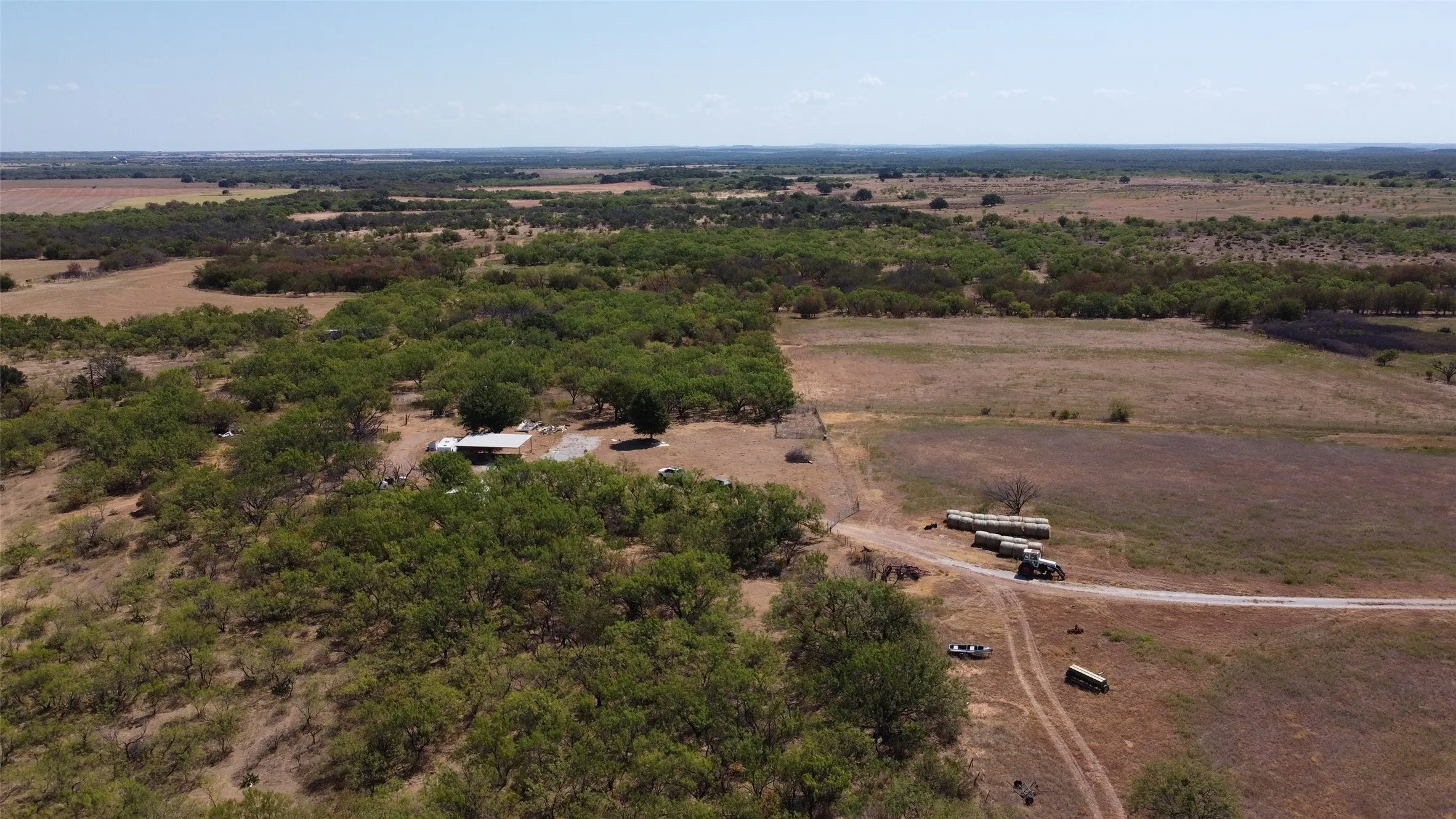 Expansive rural landscape featuring a mix of open fields and scattered treed areas