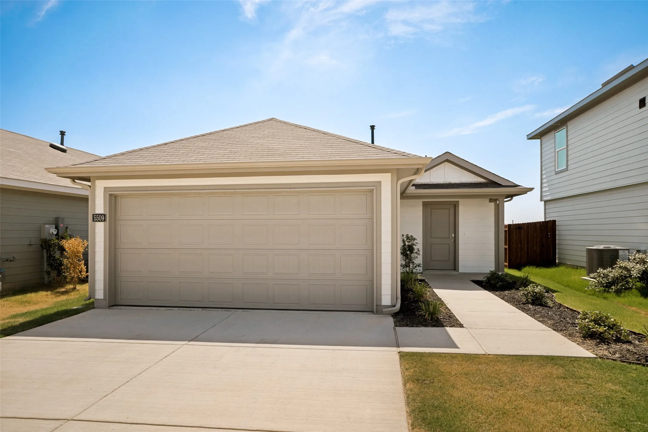 Exterior featuring a two-car garage, concrete driveway, and covered entry
