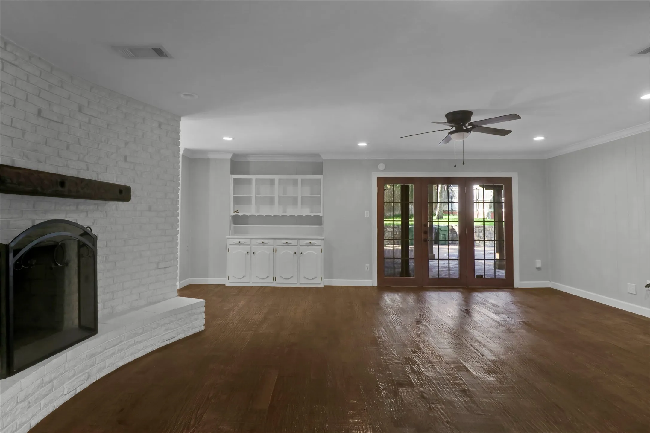 Family room with built in cabinets and shelves an access to patio.