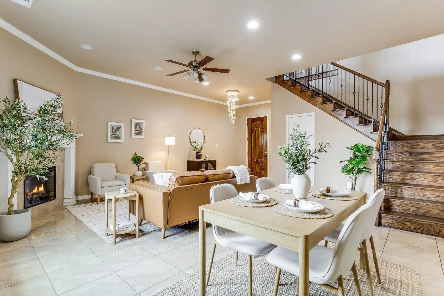 Open-concept living area with tile flooring, a fireplace featuring a decorative mantel, and a ceiling fan