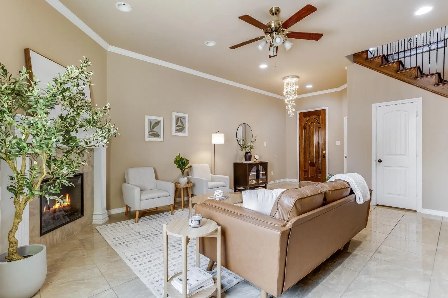 Vaulted ceiling with recessed lighting, tile flooring, built-in fireplace, wood staircase with iron balusters, and a decorative front entry door