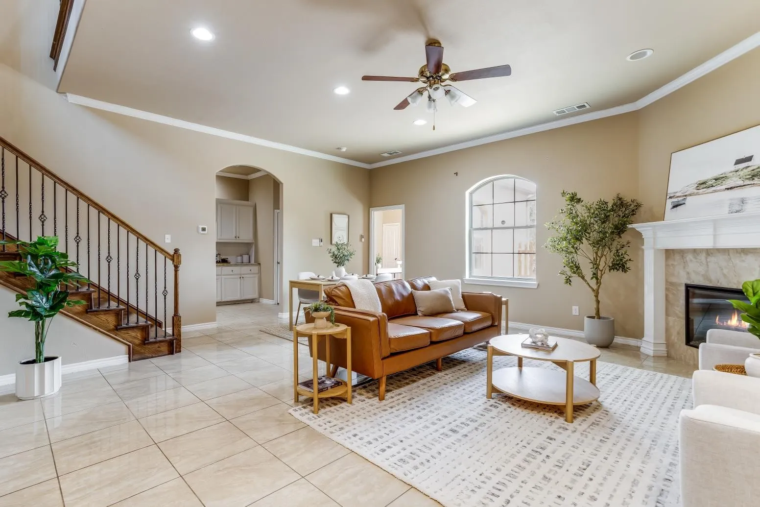 Recessed lighting, ceiling fan, fireplace with mantel, tiled flooring, and arched entryway