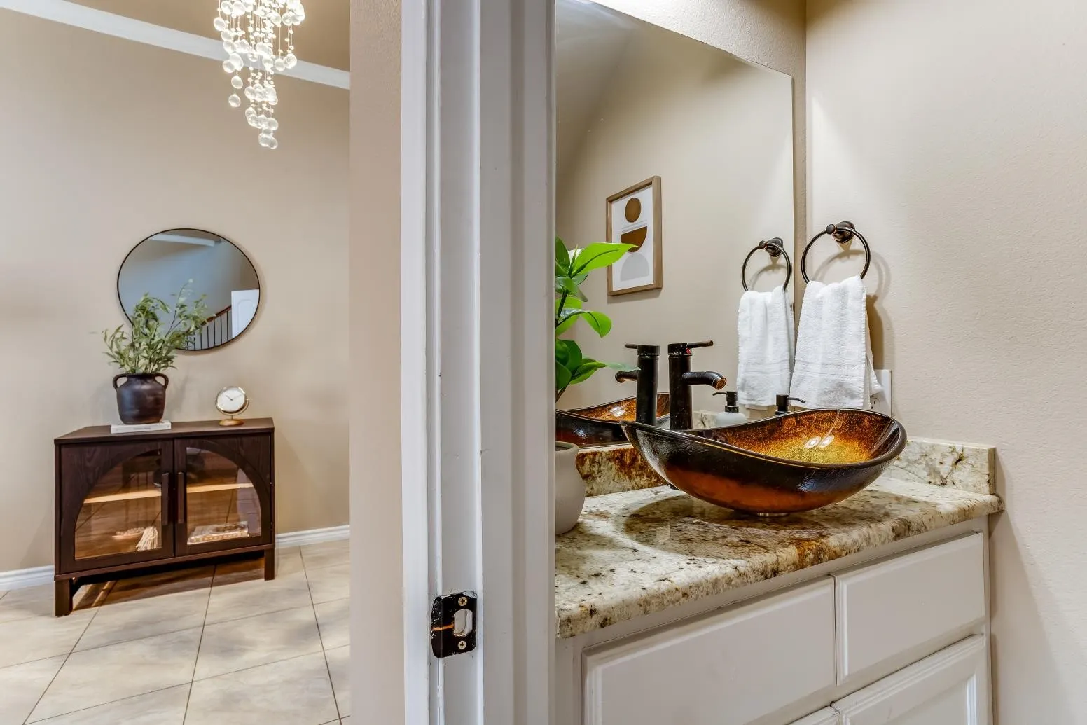 Powder room with a vessel sink, dark bronze fixtures, and a vanity with a light-colored countertop
