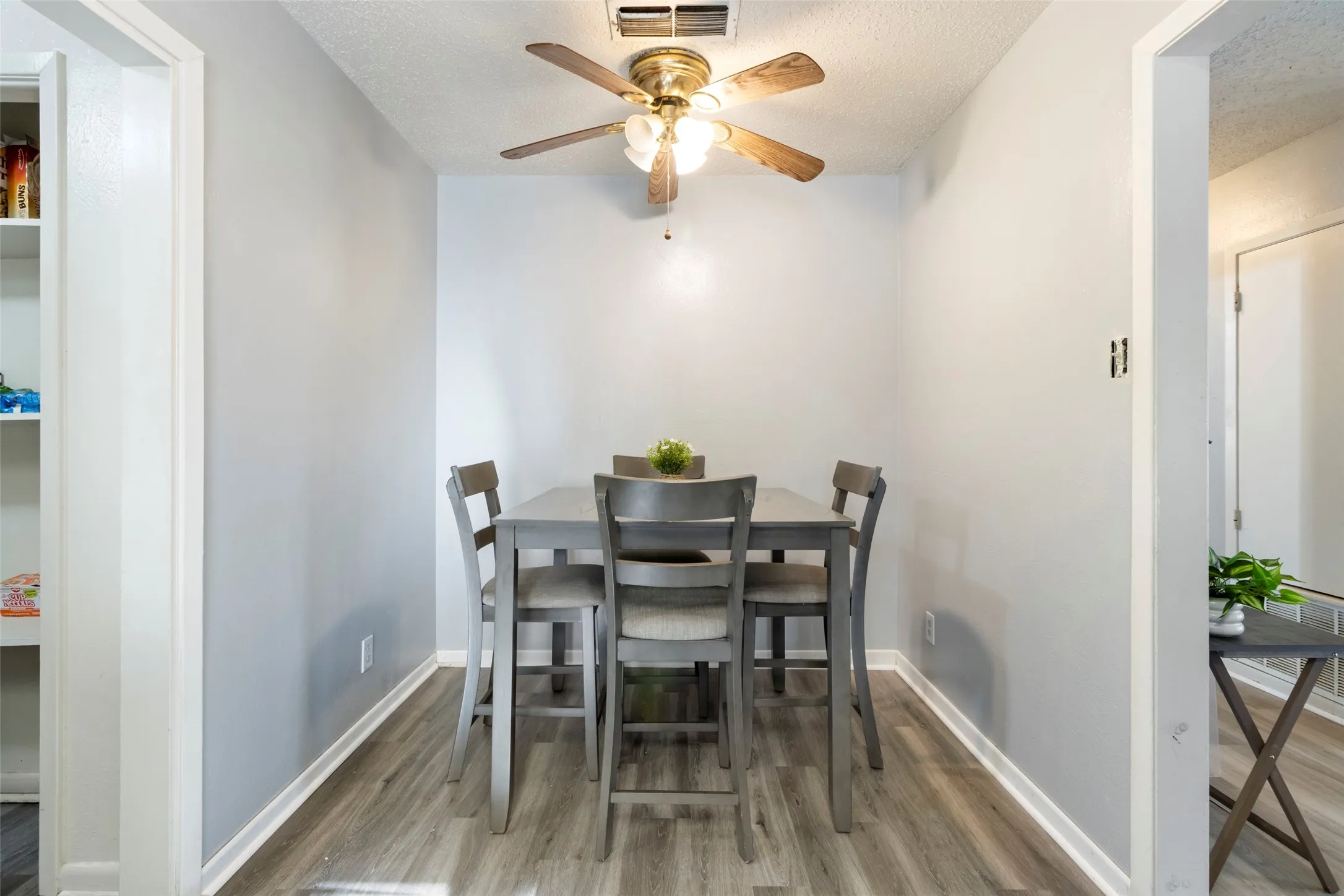 Wood-finish flooring with white trim and light gray walls