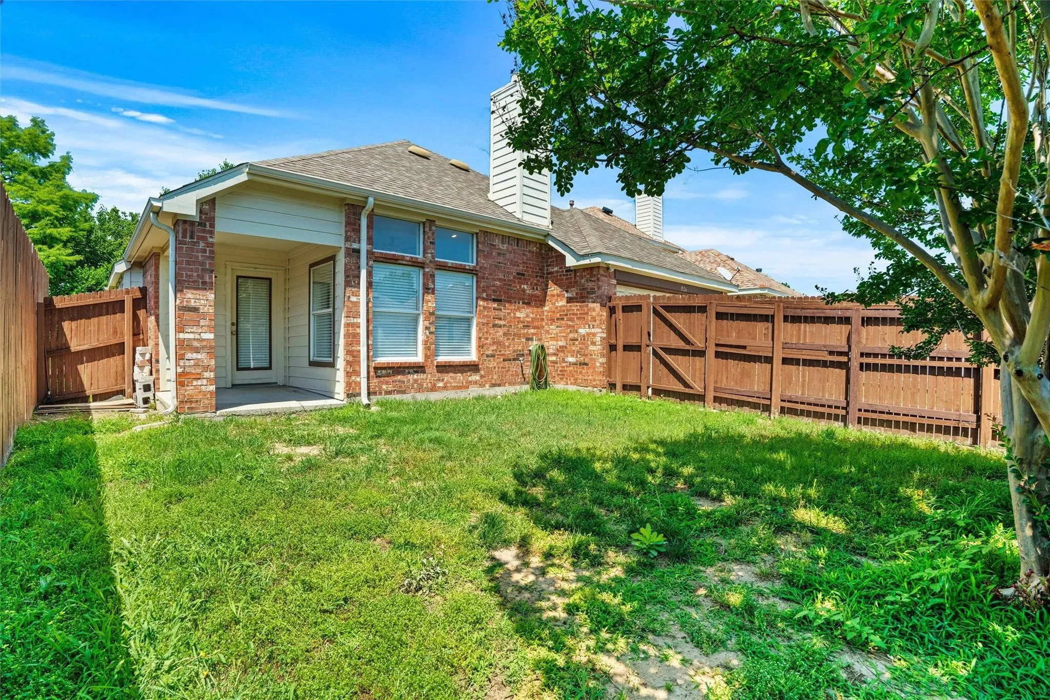 Brick exterior with a covered patio and a private fenced yard