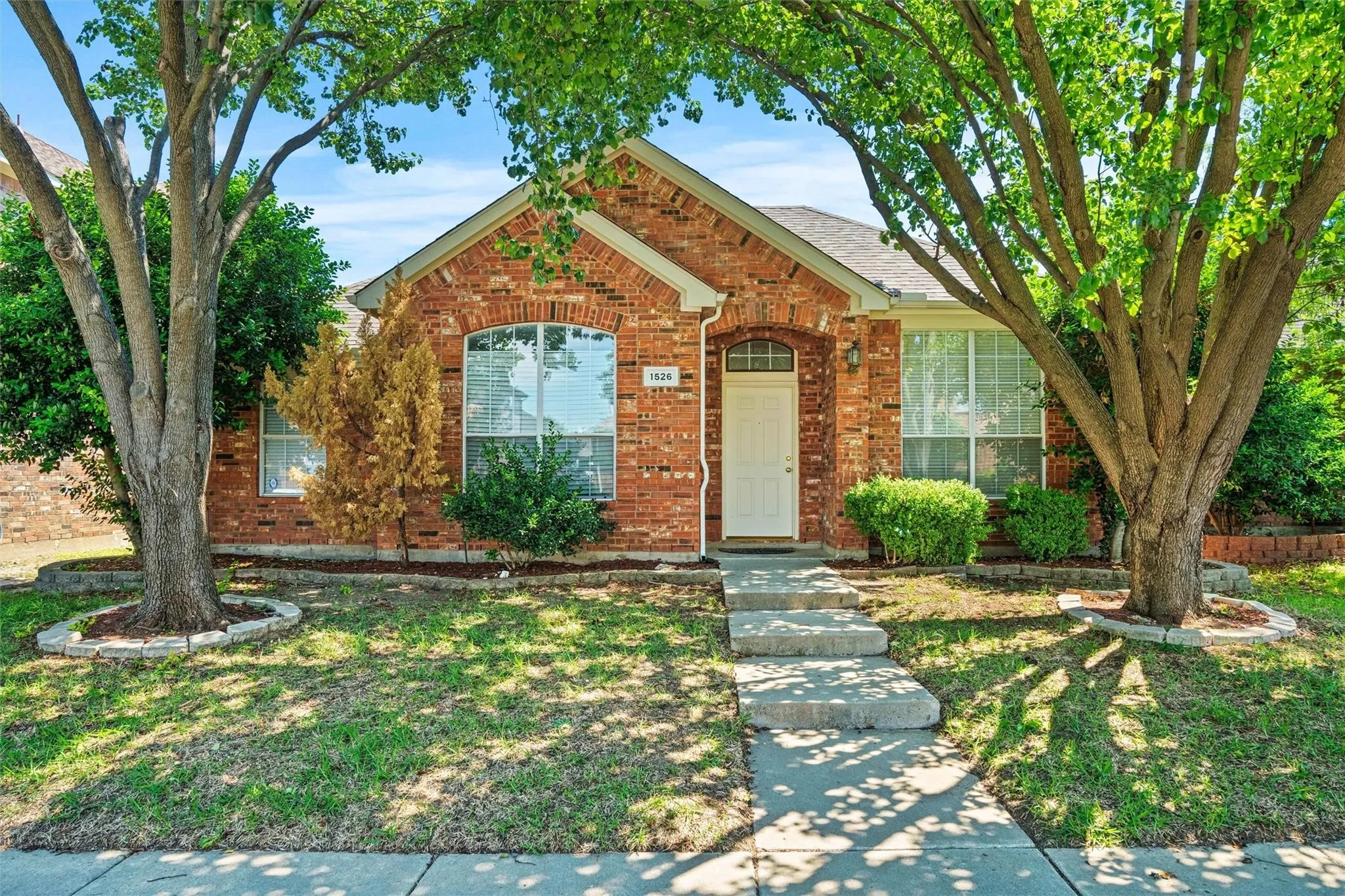 Brick exterior with an arched entry window and white front door