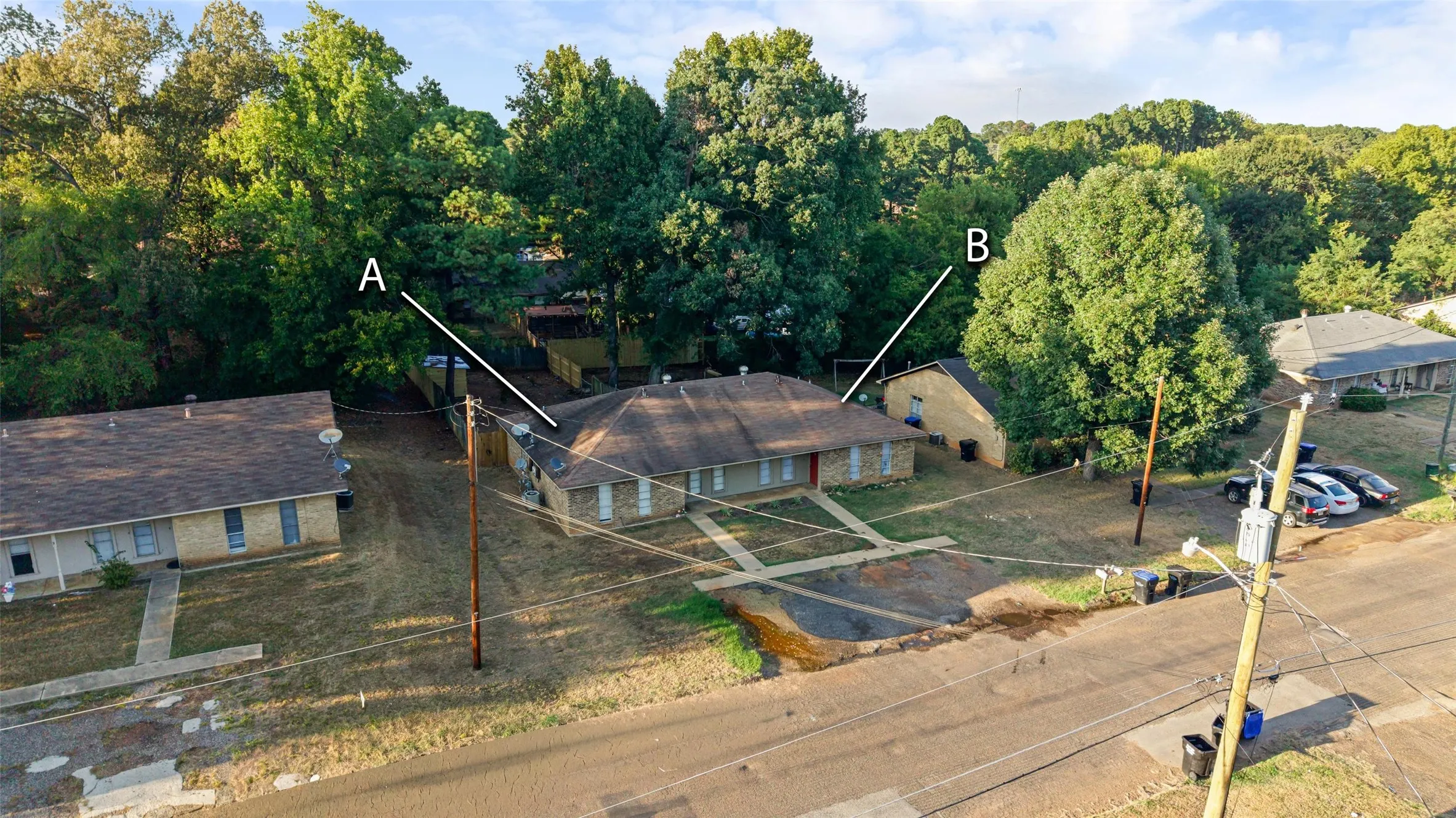 Multiple residential structures on an expansive lot with mature trees