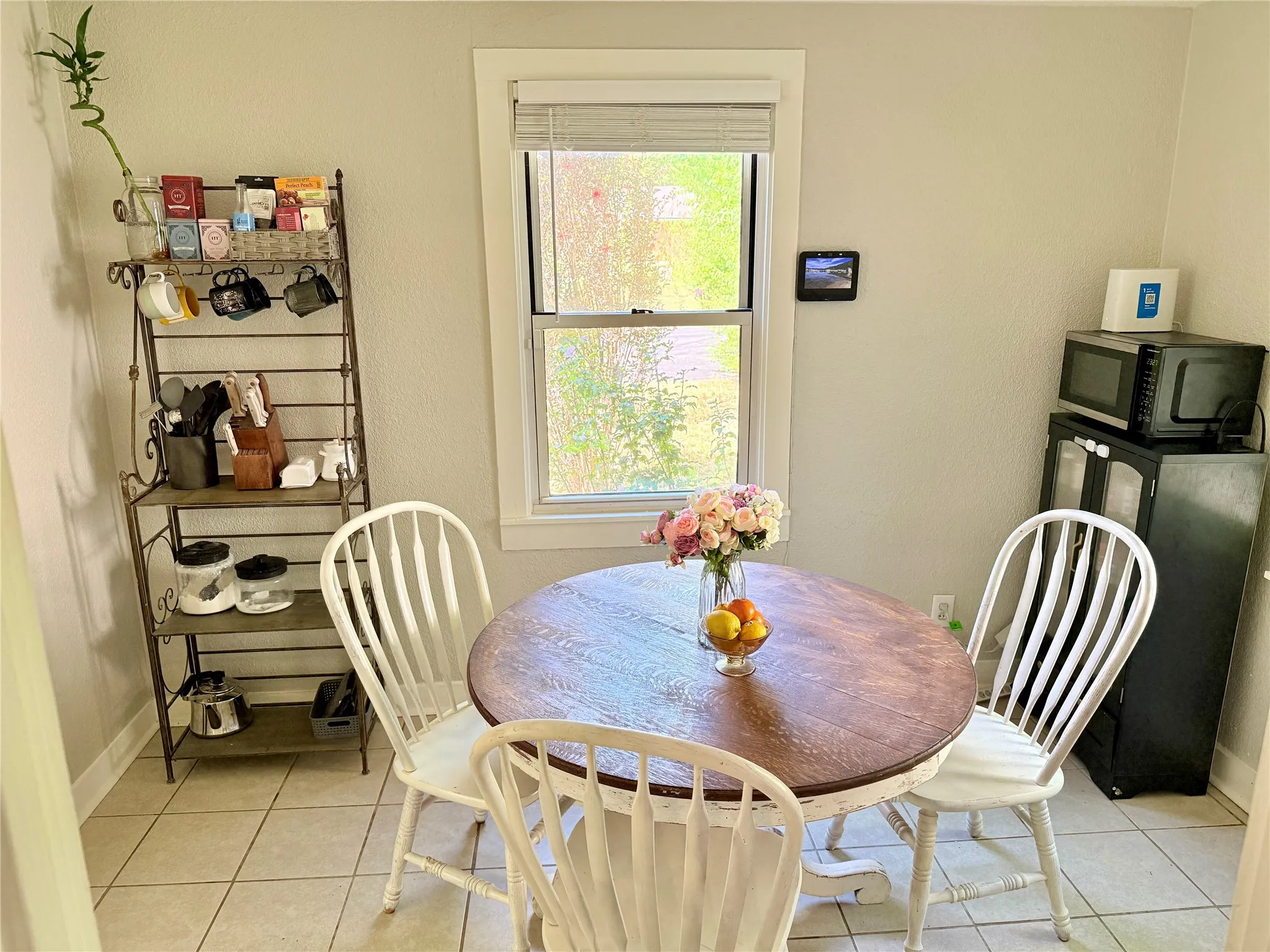 Neutral wall paint, tile flooring, and a window with blinds