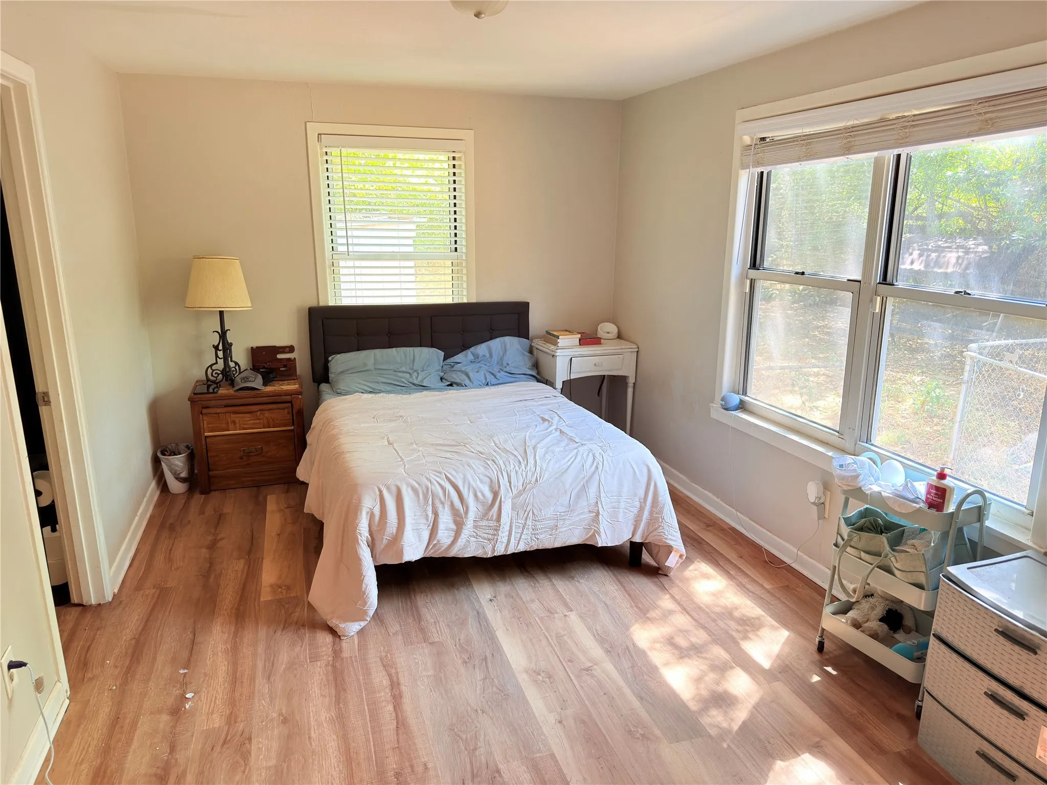 Wood-finish flooring throughout, multiple windows, and neutral wall tones