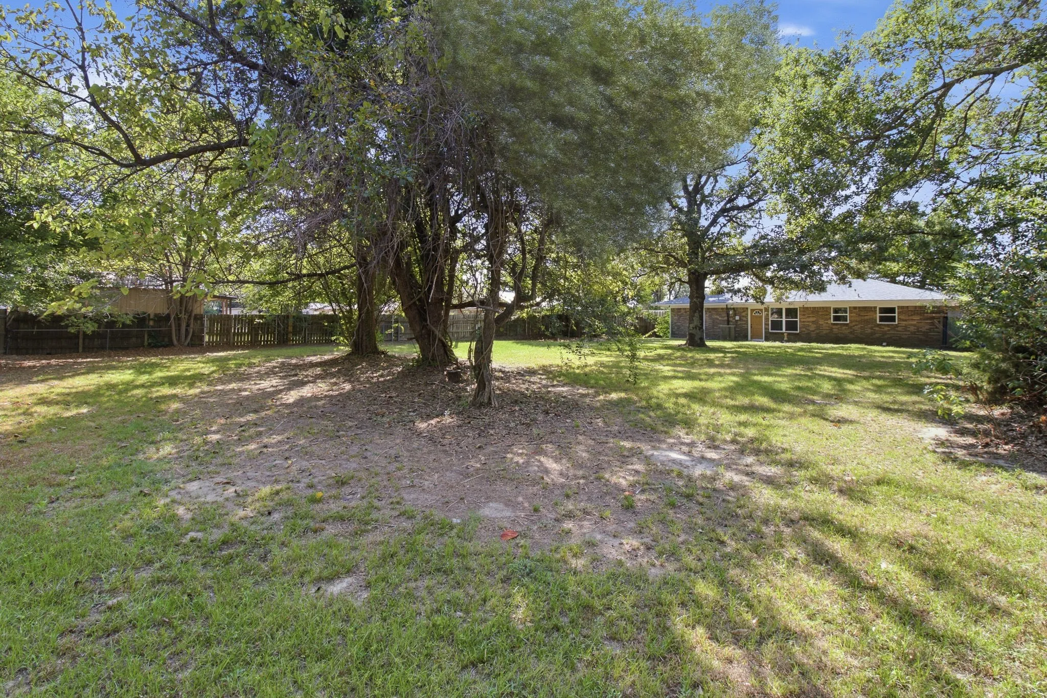 Expansive grassy yard with mature trees