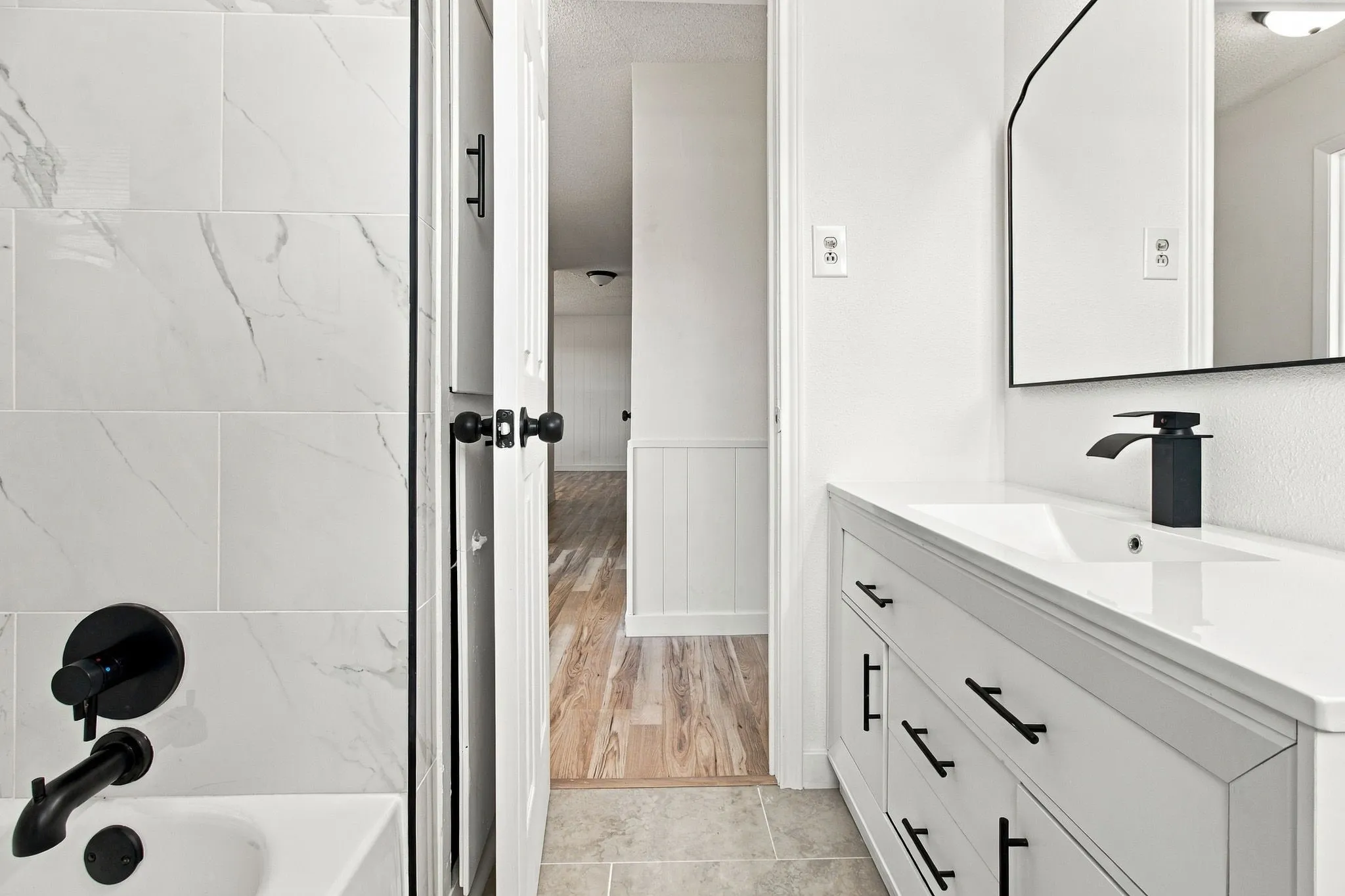 White vanity with integrated sink and matte black faucet