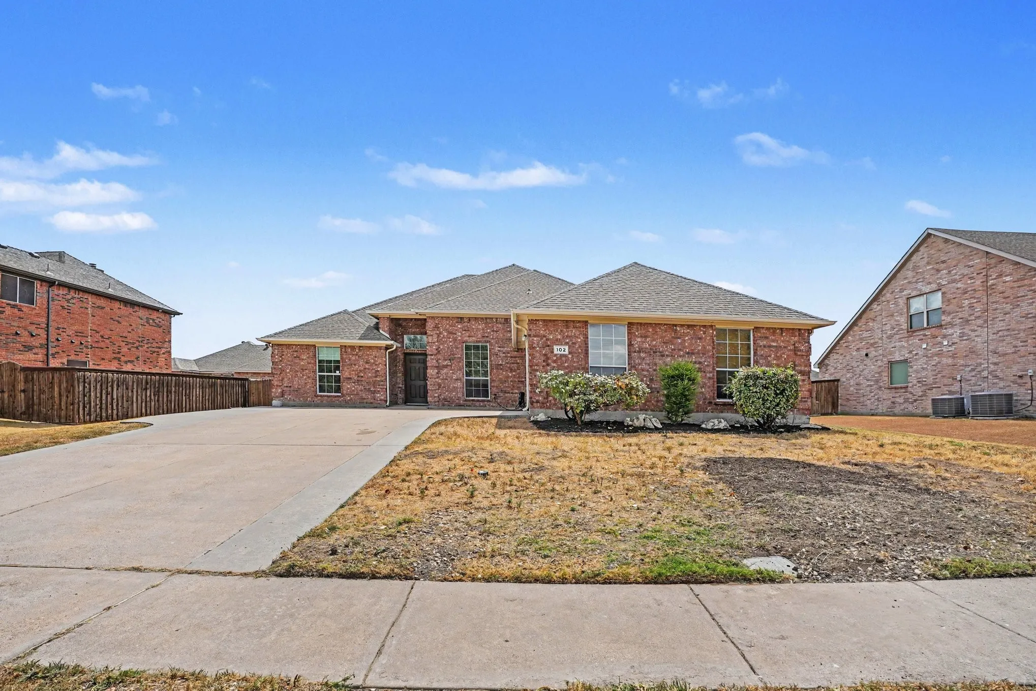 Brick exterior with a gabled roof and a concrete driveway