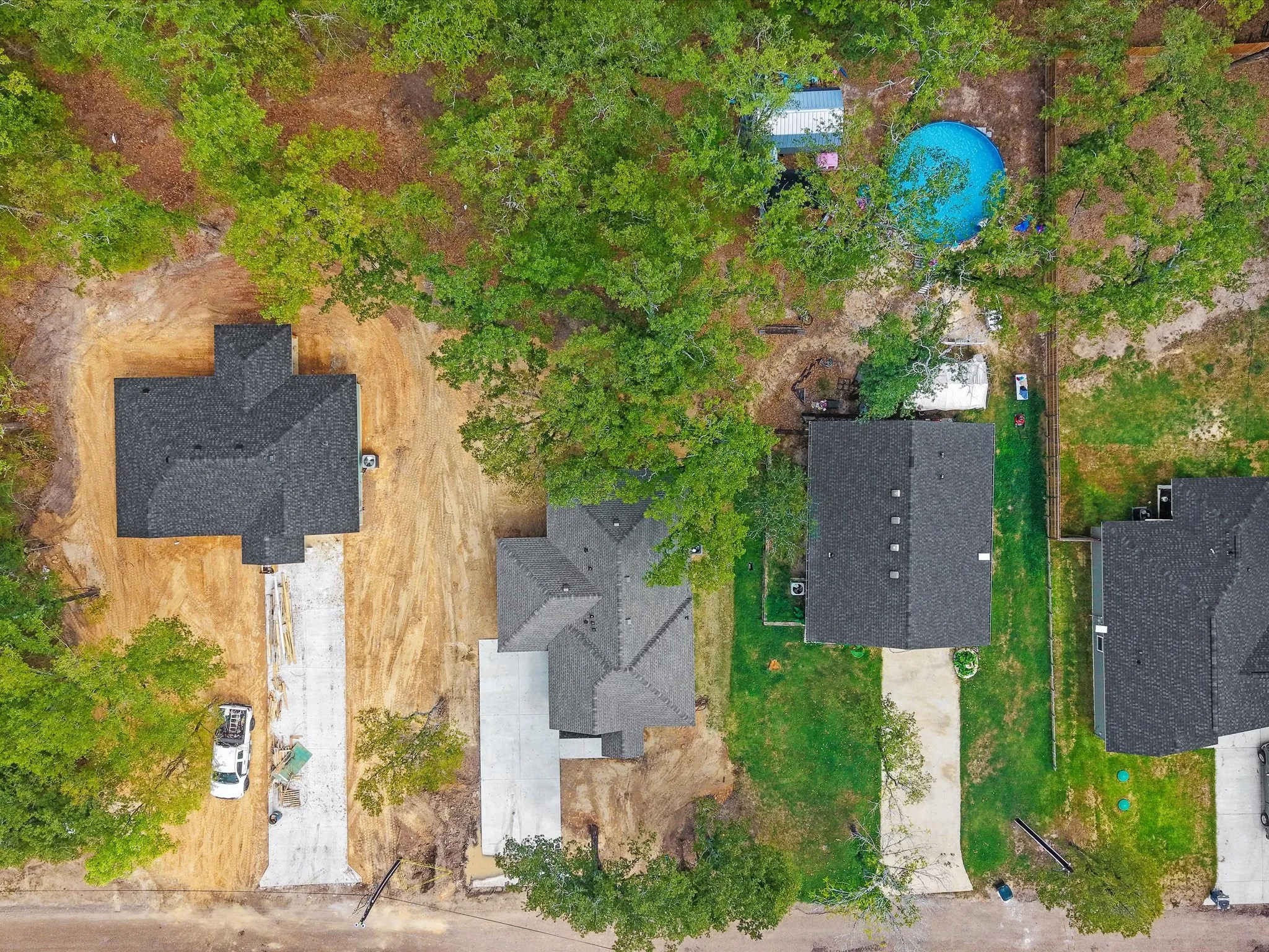 Newly constructed residence featuring a dark shingle roof and a concrete driveway