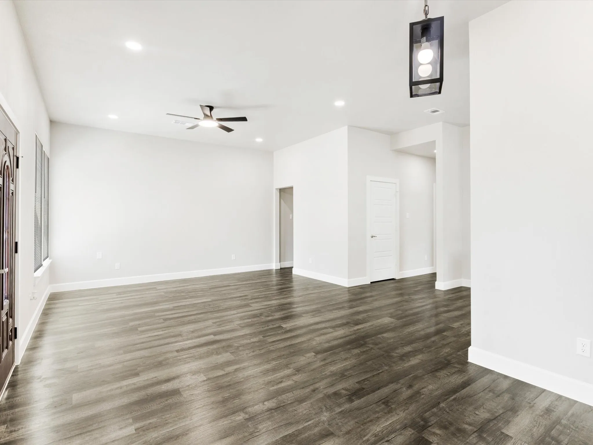 Vaulted ceiling with recessed lighting, wood-finish flooring, and a modern ceiling fan