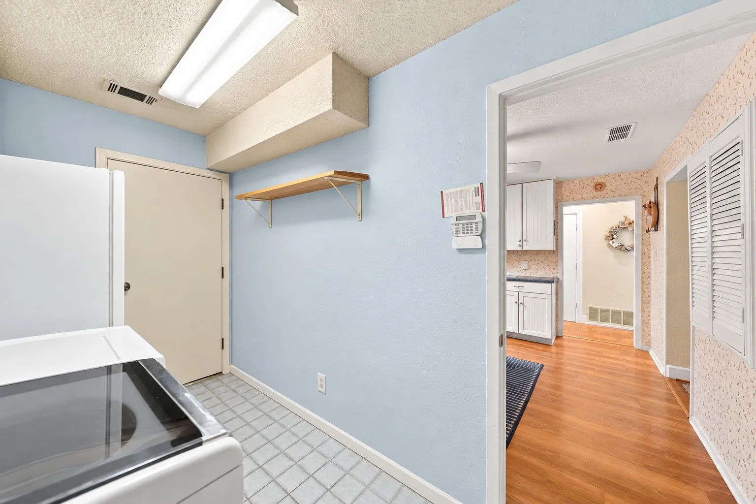 Utility area featuring tile flooring and a wall-mounted shelf