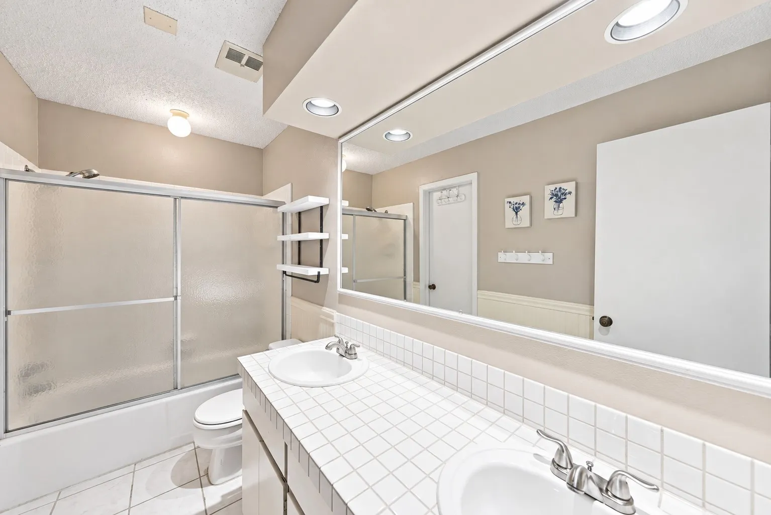 Dual vanity with tile countertop, undermount sinks, and chrome faucets