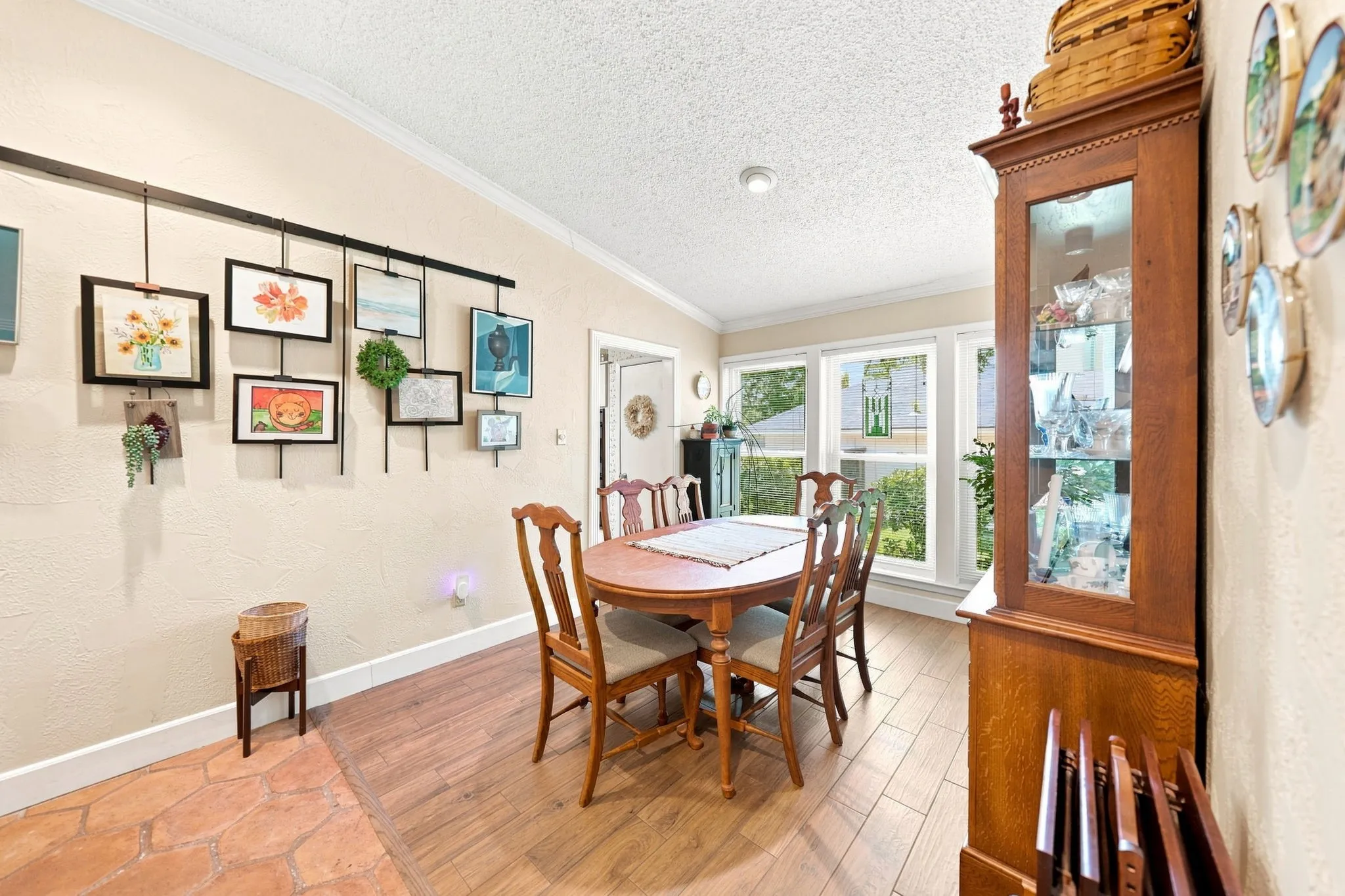 Expansive dining area featuring wood-finish flooring, multiple windows, and crown molding