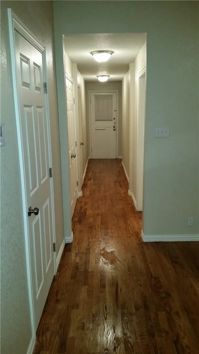 Hallway that leads to 2 bedrooms and full washer and dryer connection. All hardwood floor.
