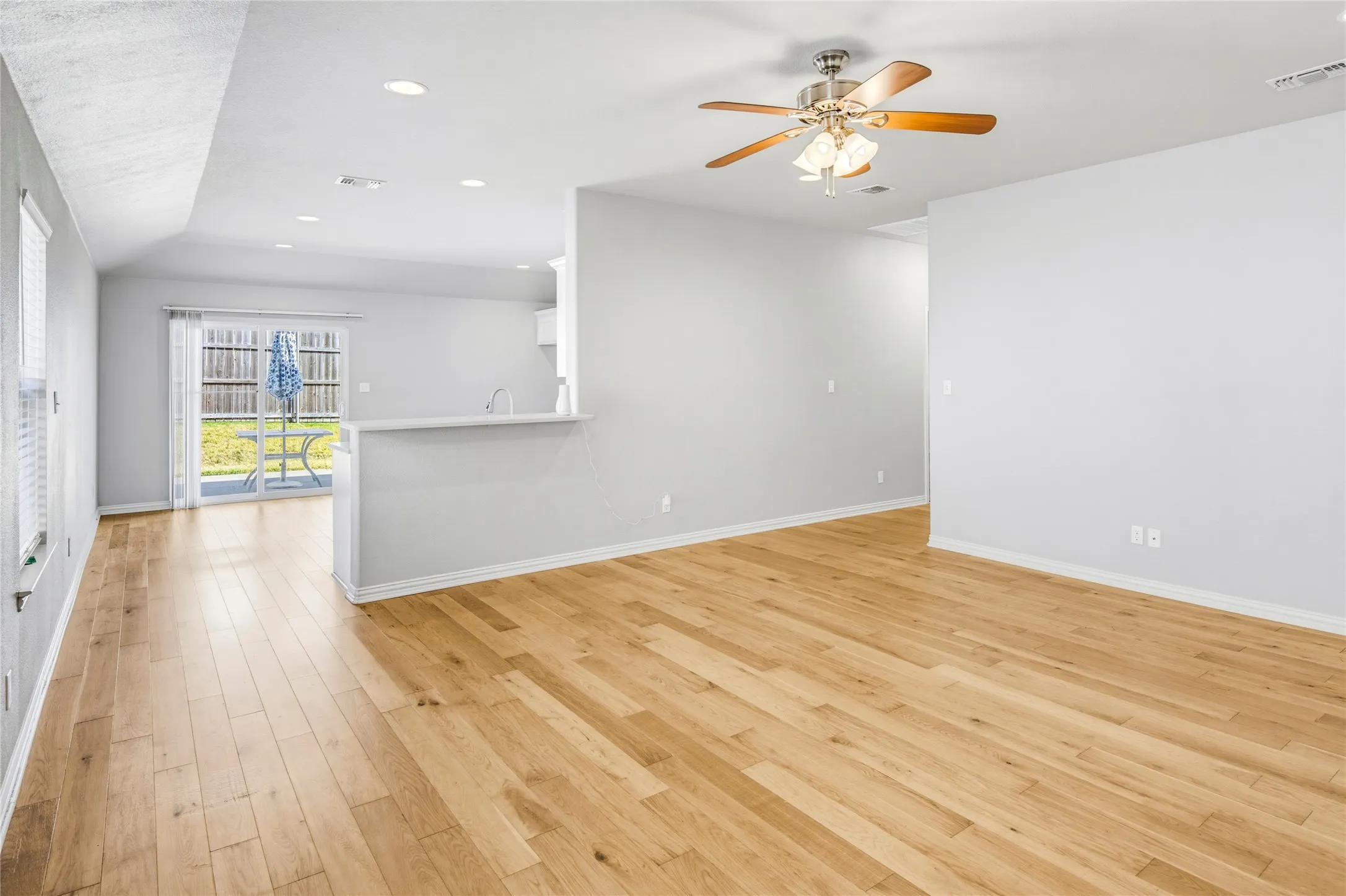 Wood-finish flooring throughout, recessed lighting, ceiling fan, and sliding glass door to outdoor​​‌​​​​‌​​‌‌​‌‌​​​‌‌​‌​‌​‌​​​‌​​ patio